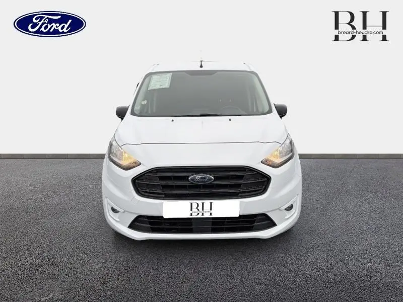 Vue de face d'un Ford Transit Connect L1 blanc glacier, avec calandre noire et phares allumés sur fond neutre.