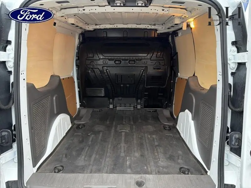 Vue arrière intérieure du Ford Transit Connect blanc glacier, montrant l'espace de chargement avec cloison complète tôlée.
