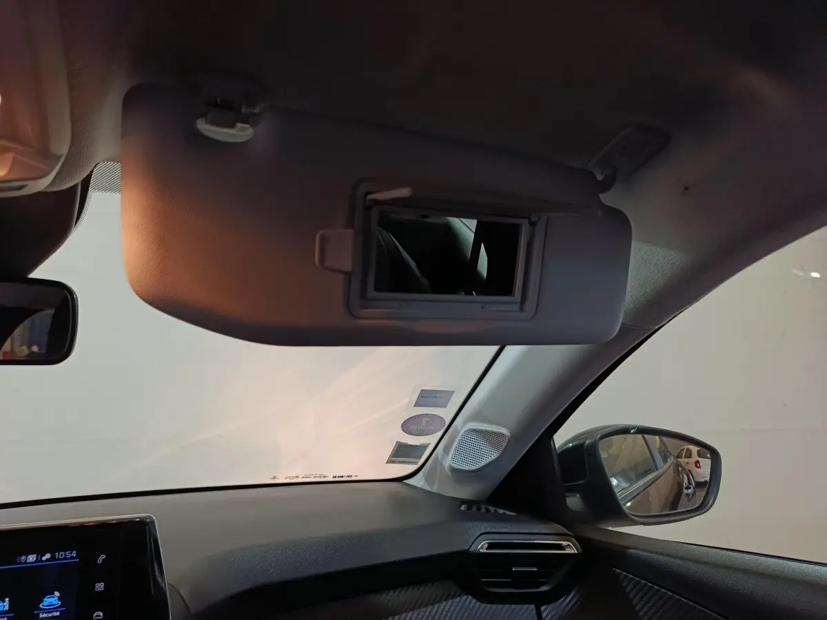Intérieur de la Peugeot 208 1.2 PT 75 S&S Premium 2022, vue côté passager avec pare-soleil et miroir ouvert.