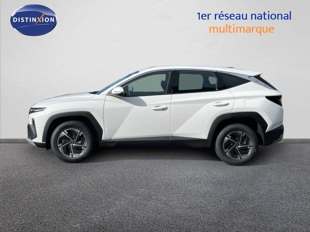 Vue de profil droit du Hyundai Tucson 2026 blanc Atlas avec jantes alliage et lignes anguleuses marquées.