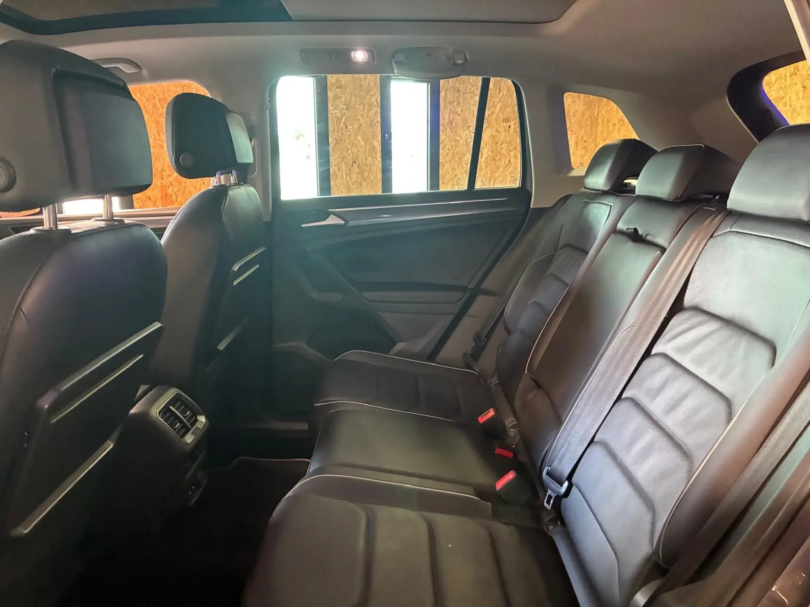 Vue intérieure arrière côté droit du Volkswagen Tiguan 2020, sièges en cuir noir et ceinture de sécurité visibles.