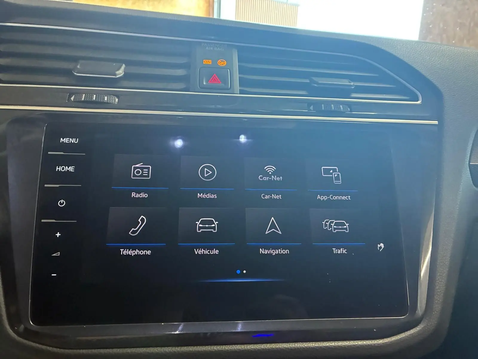 Écran tactile central du tableau de bord du Volkswagen Tiguan gris, affichant le menu multimédia et navigation.