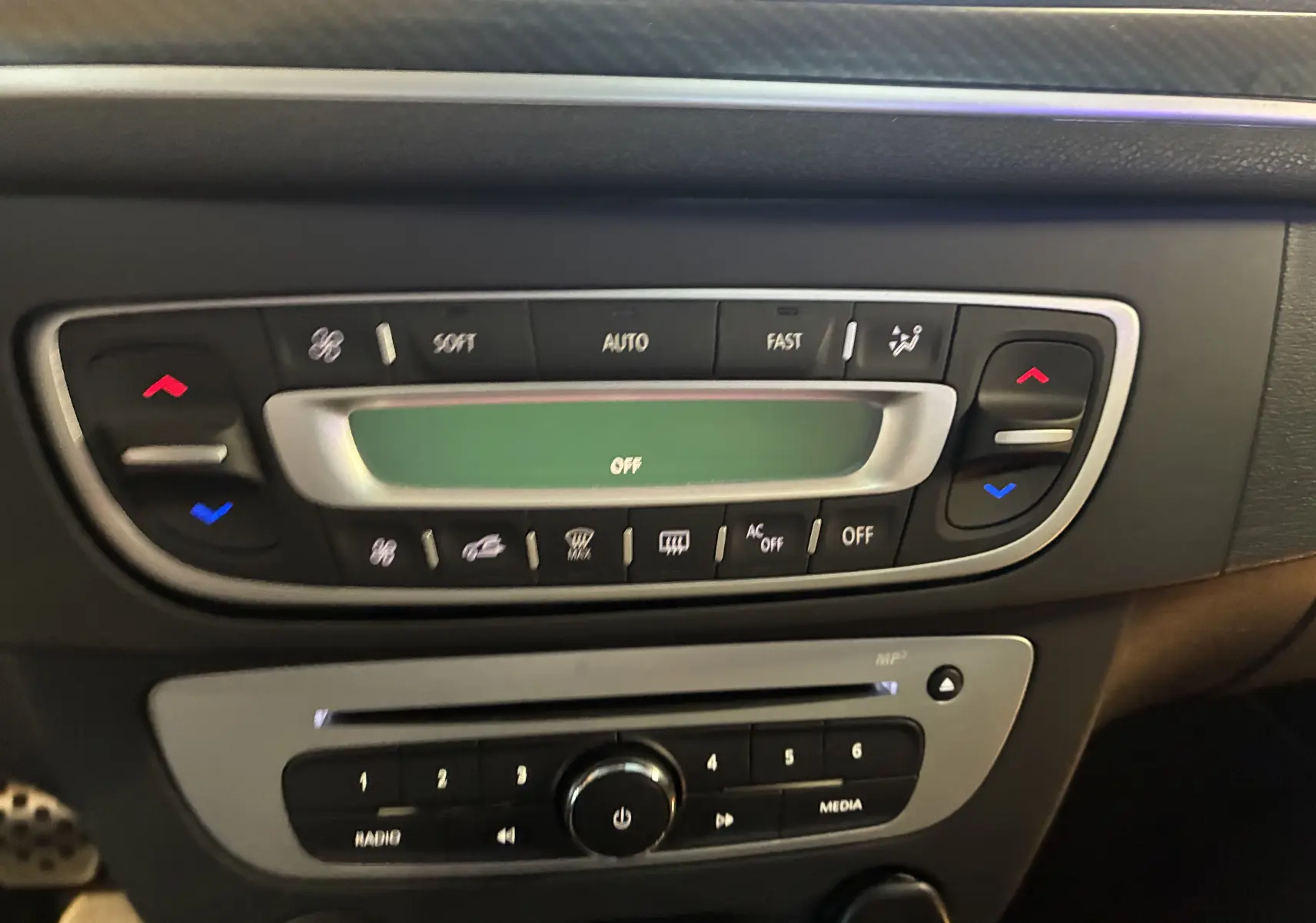 Vue rapprochée de la console centrale de la Renault Mégane Coupé 2.0 DCI 165 GT avec commandes climatisation et radio.
