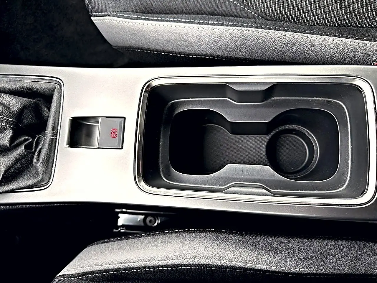 Vue rapprochée de la console centrale noire et argentée de l'Opel Mokka 1.2 turbo 136 edition avec levier de vitesse manuel.