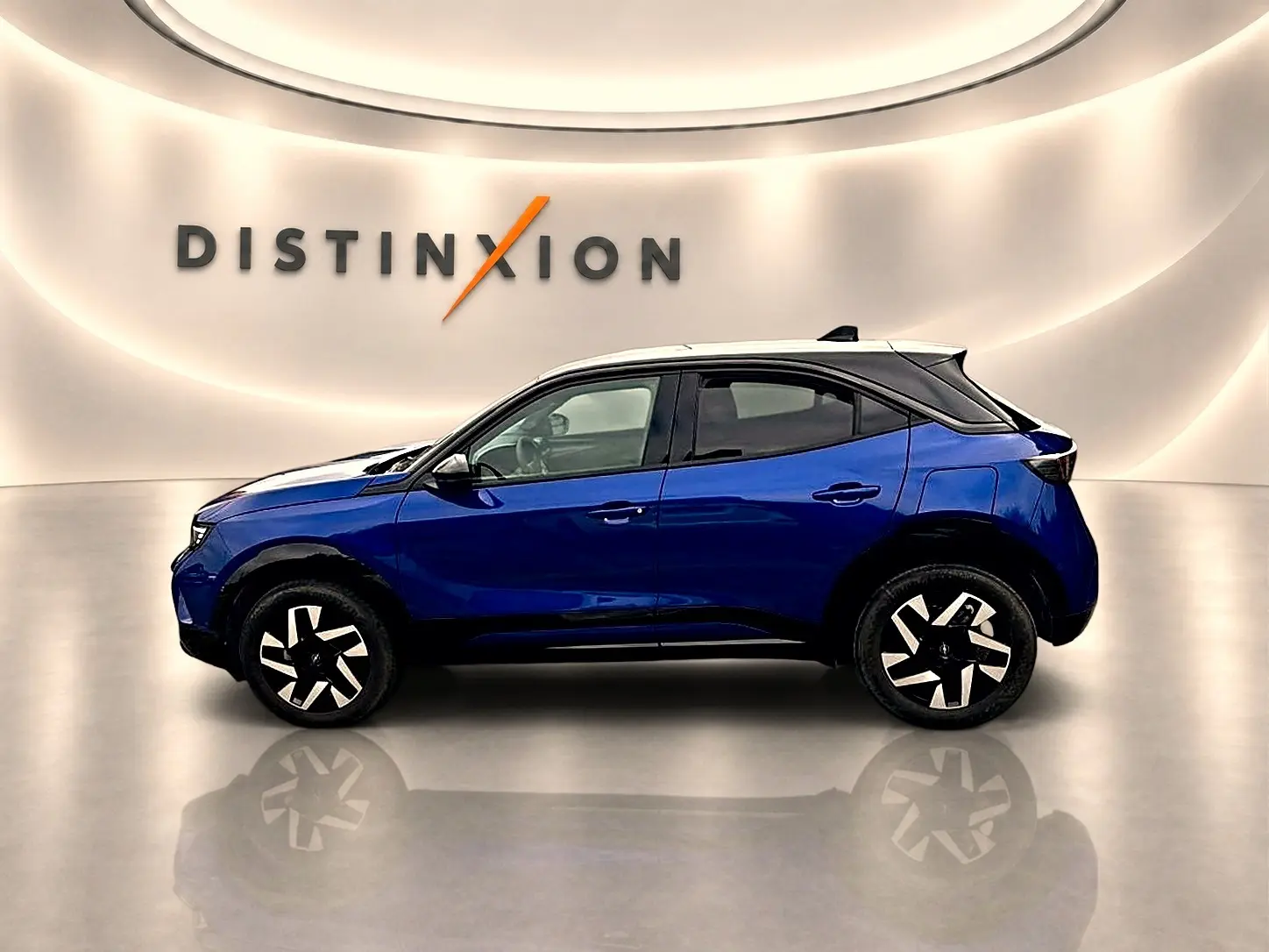 Opel Mokka bleu en profil droit, toit noir contrastant et jantes au design moderne en showroom lumineux.