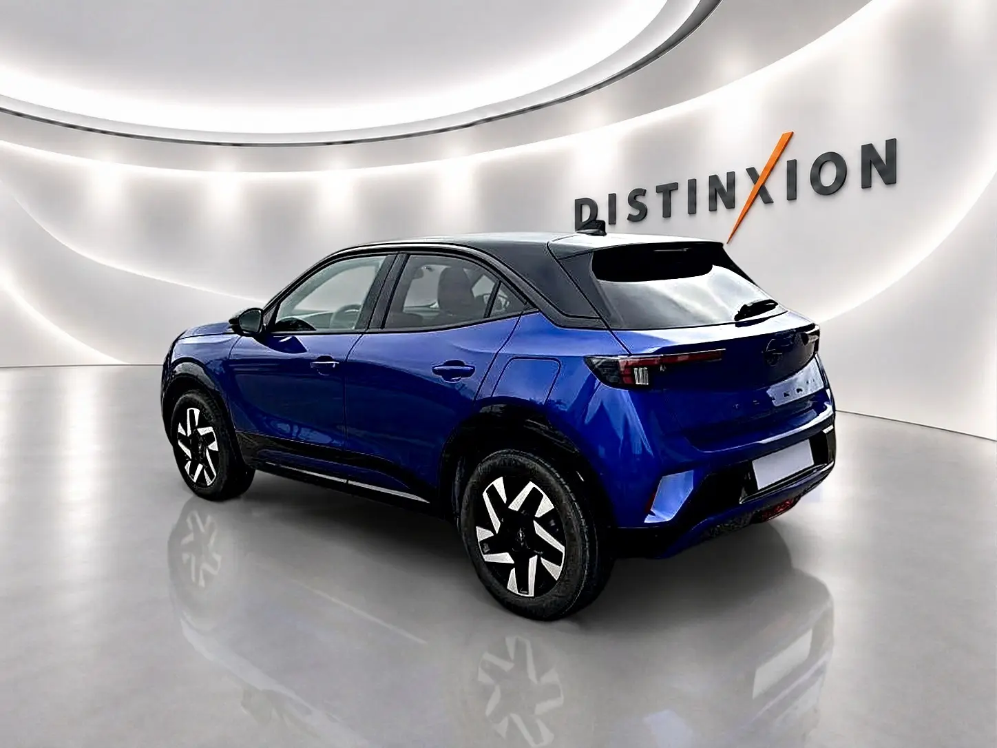 Opel Mokka 1.2 turbo bleu en 3/4 arrière droit, toit noir et jantes au design moderne.