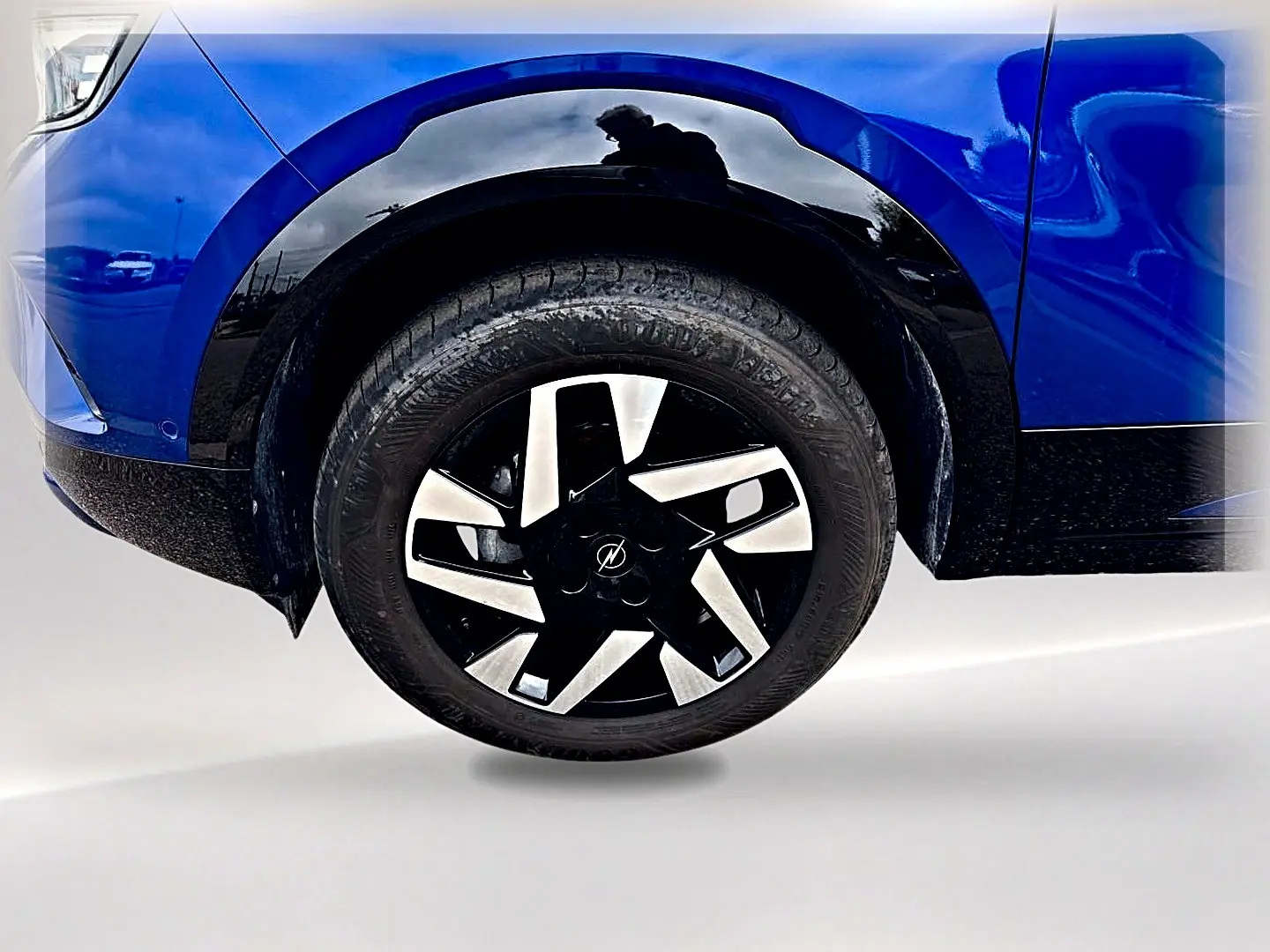 Gros plan sur la roue avant droite d’un Opel Mokka bleu 2025 avec jante noire et argentée au design moderne.