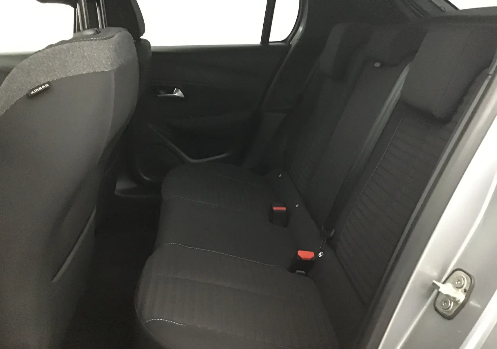 Vue intérieure côté droit des sièges arrière noirs d'une Peugeot 208 1.2 PureTech 100 Style Gris Artense 2022.