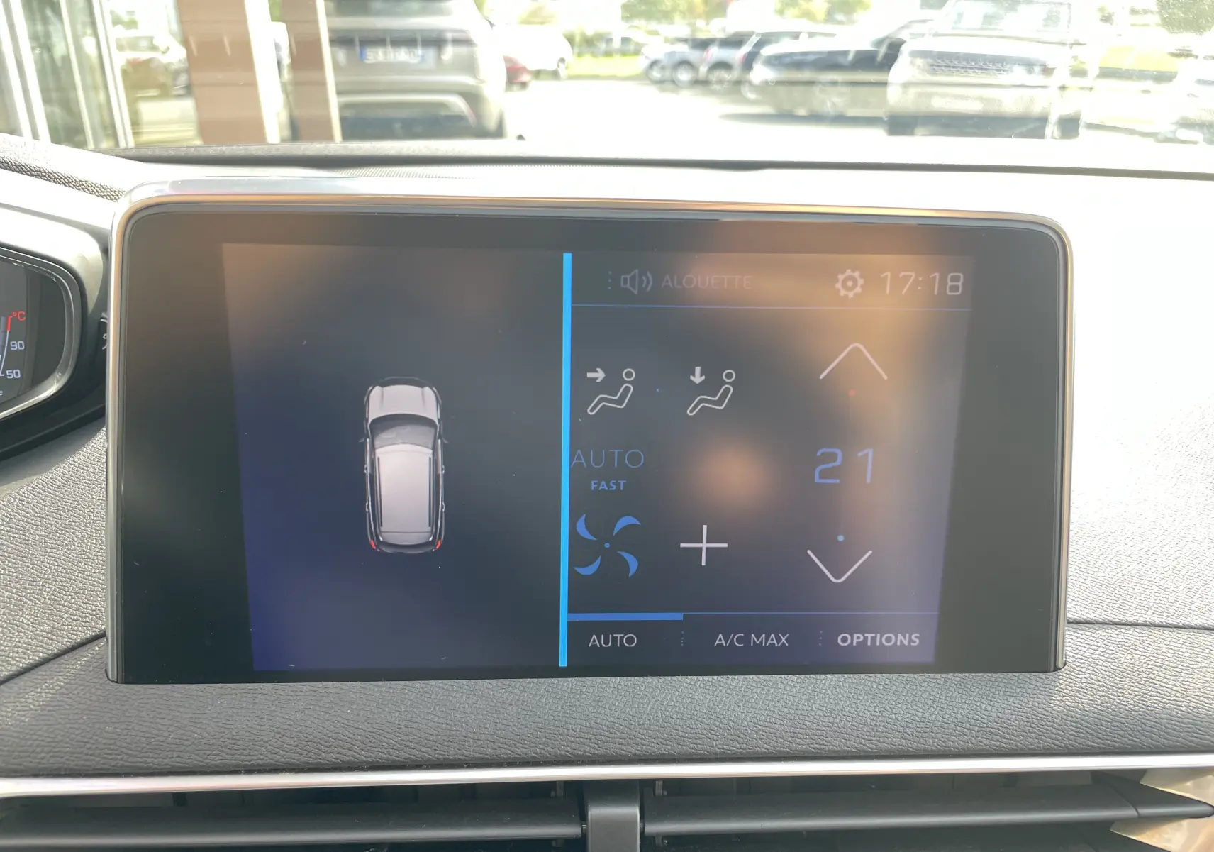 Écran tactile du tableau de bord du Peugeot 3008 blanc de 2018, affichant la climatisation à 21 degrés et la vue du véhicule en haut.