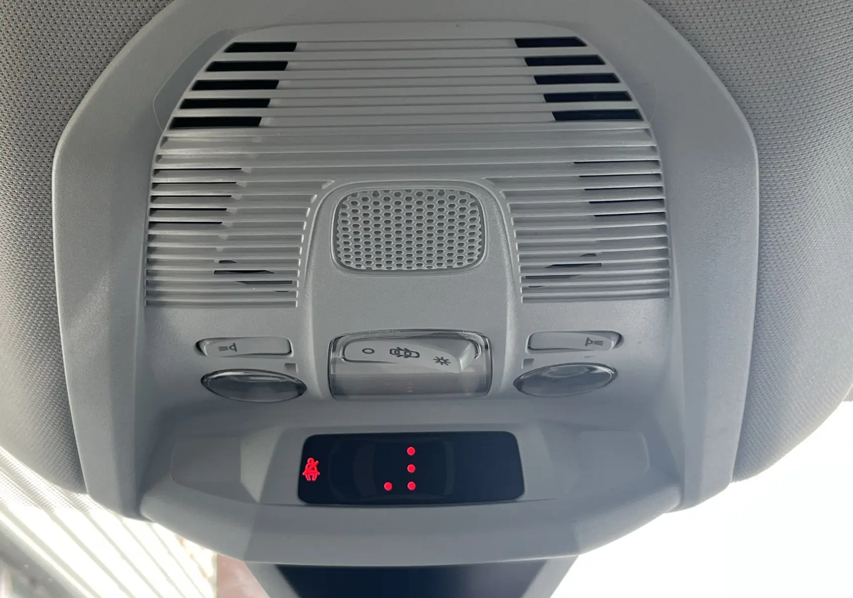 Vue en gros plan du plafonnier gris clair avec commandes d’éclairage et indicateur rouge à l’intérieur d’un Peugeot 3008 blanc.