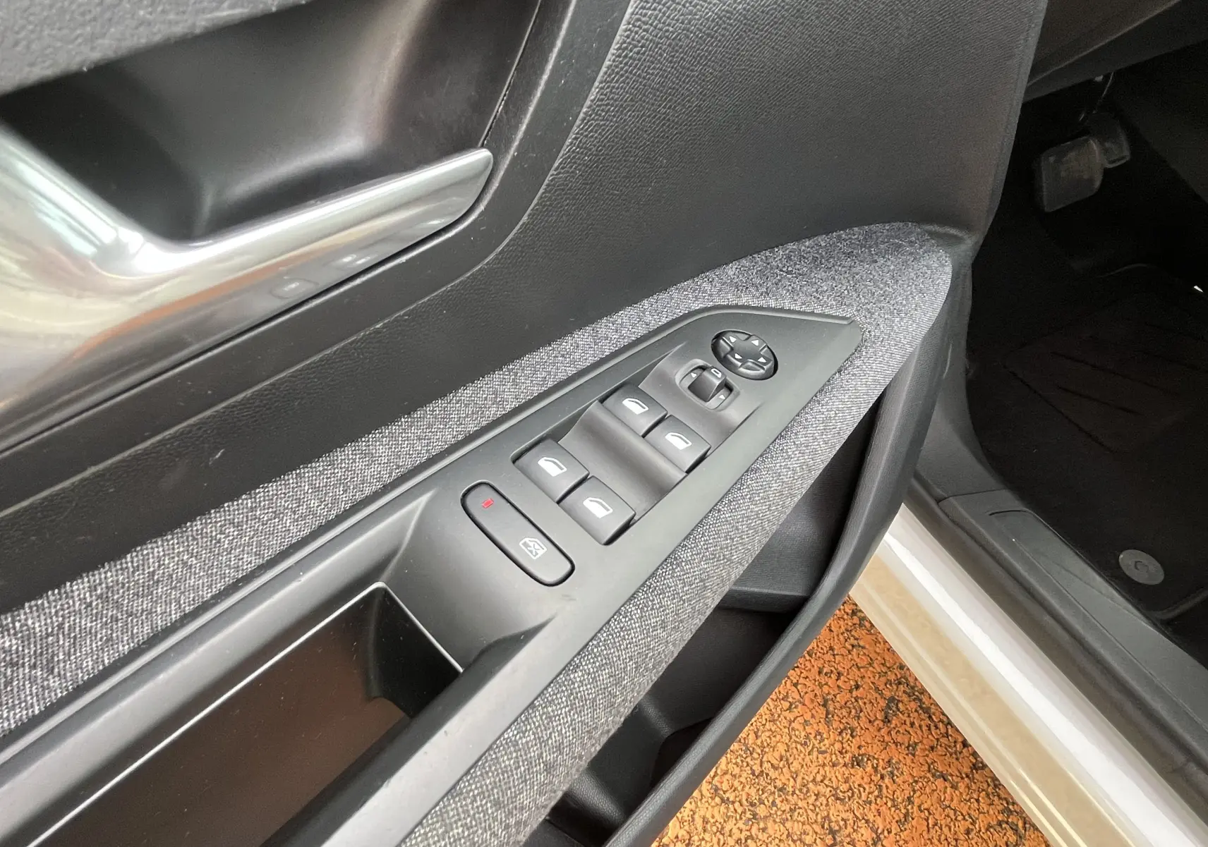 Gros plan sur la commande des vitres électriques côté conducteur du Peugeot 3008 blanc, avec insert tissu gris.