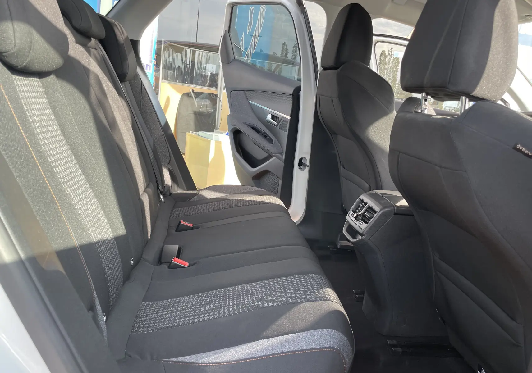 Vue intérieure arrière droite du Peugeot 3008 blanc 2018, montrant les sièges noirs et la portière ouverte.