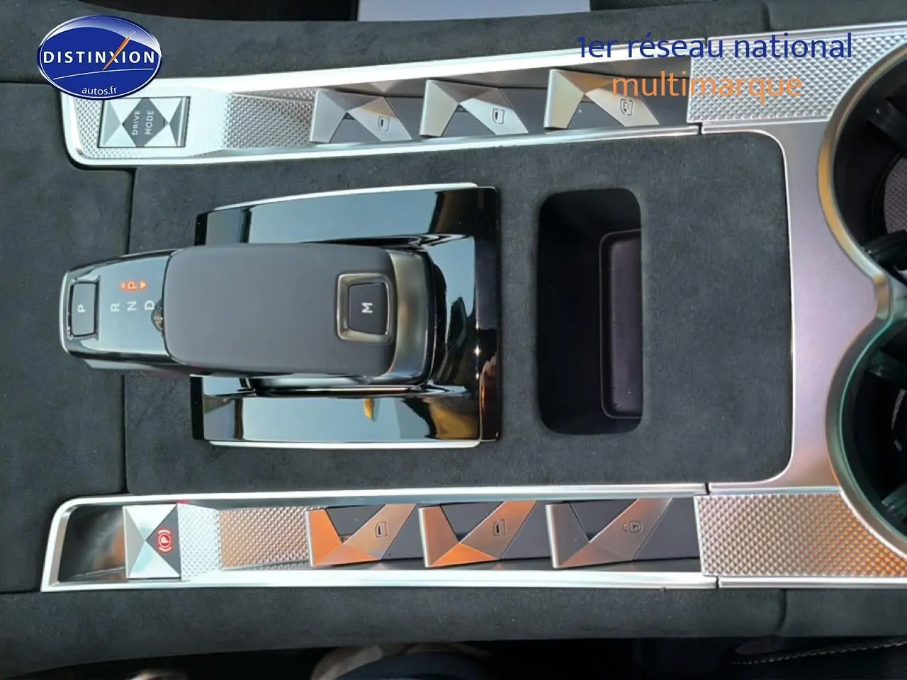 Vue plongeante sur la console centrale noire du DS7 1.5 BlueHDi 130 avec levier de vitesses automatique et boutons chromés.
