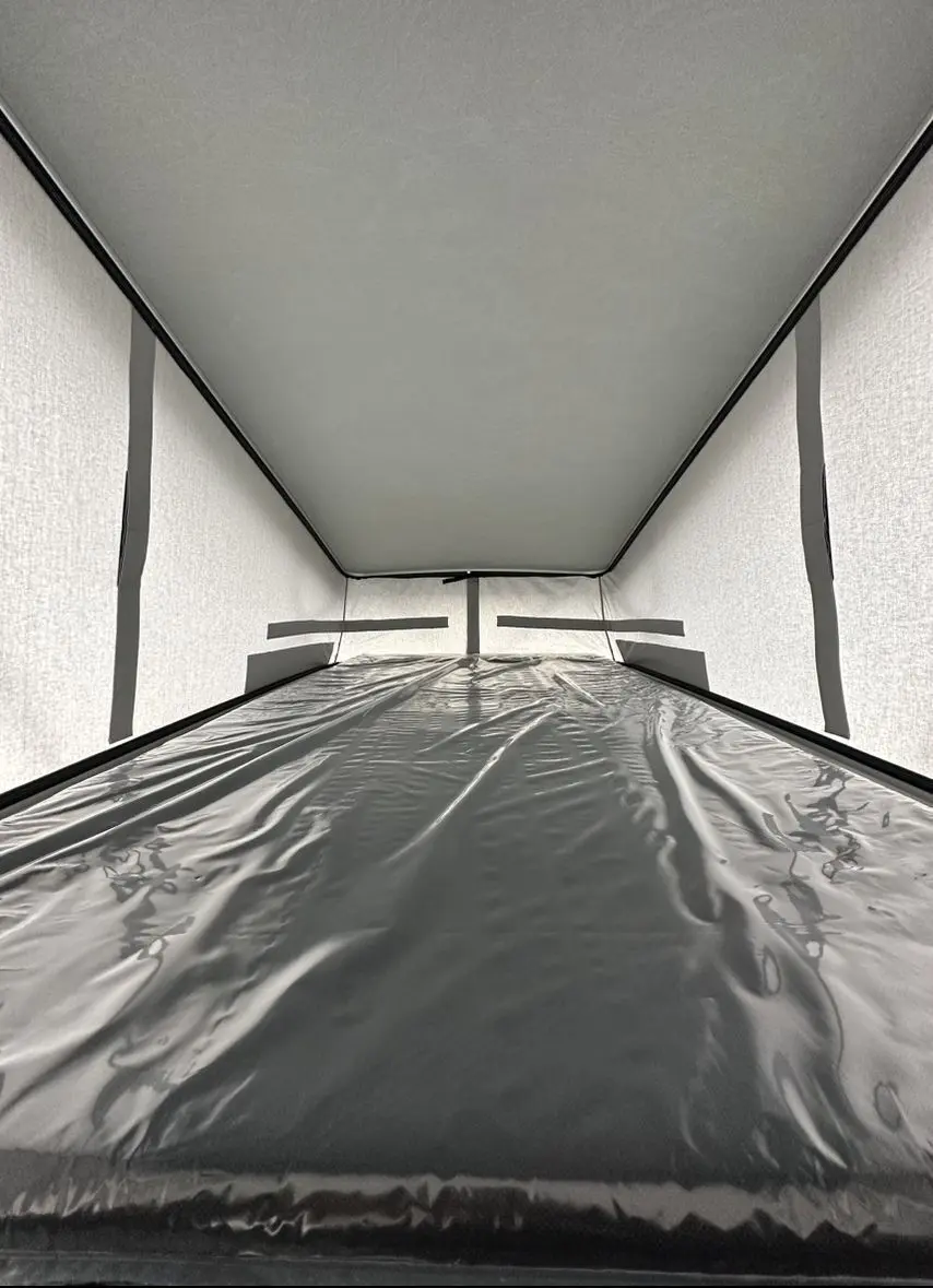 Intérieur du toit relevable du Citroën Jumpy van blanc, montrant la couchette et la toile de protection.