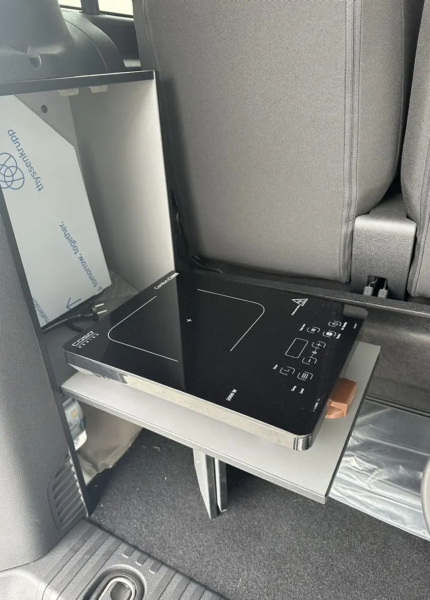 Réchaud électrique noir sur tablette coulissante à l'intérieur arrière d'un Citroën Jumpy van blanc.