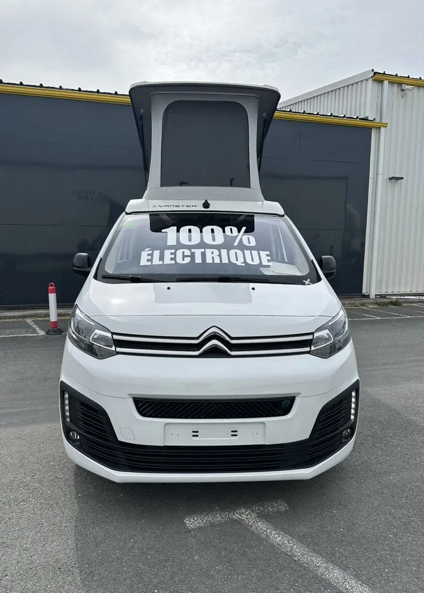 Vue de face du Citroën Jumpy van blanc avec toit relevable et inscription 100% électrique sur le pare-brise.