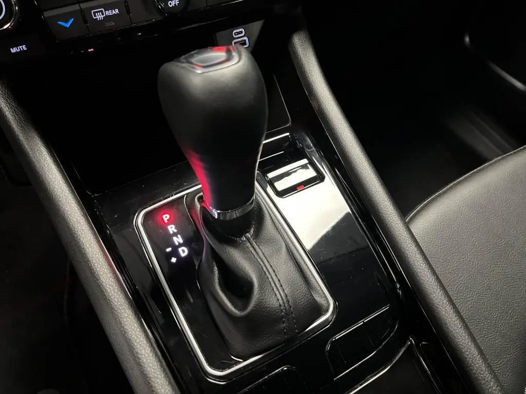 Le levier de vitesse automatique noir du Jeep Compass 2024 e-Hybride, entouré de garnitures brillantes dans l'habitacle.