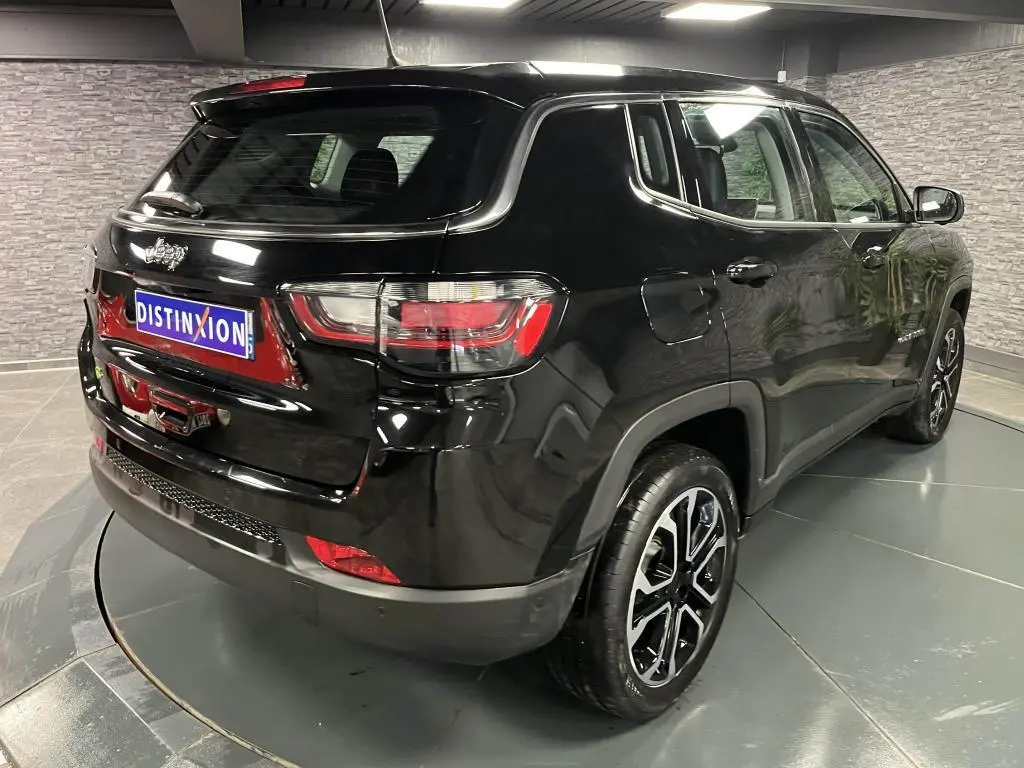 Jeep Compass noir en 3/4 arrière droit, avec jantes alliage 18 pouces et feux arrière LED distinctifs.