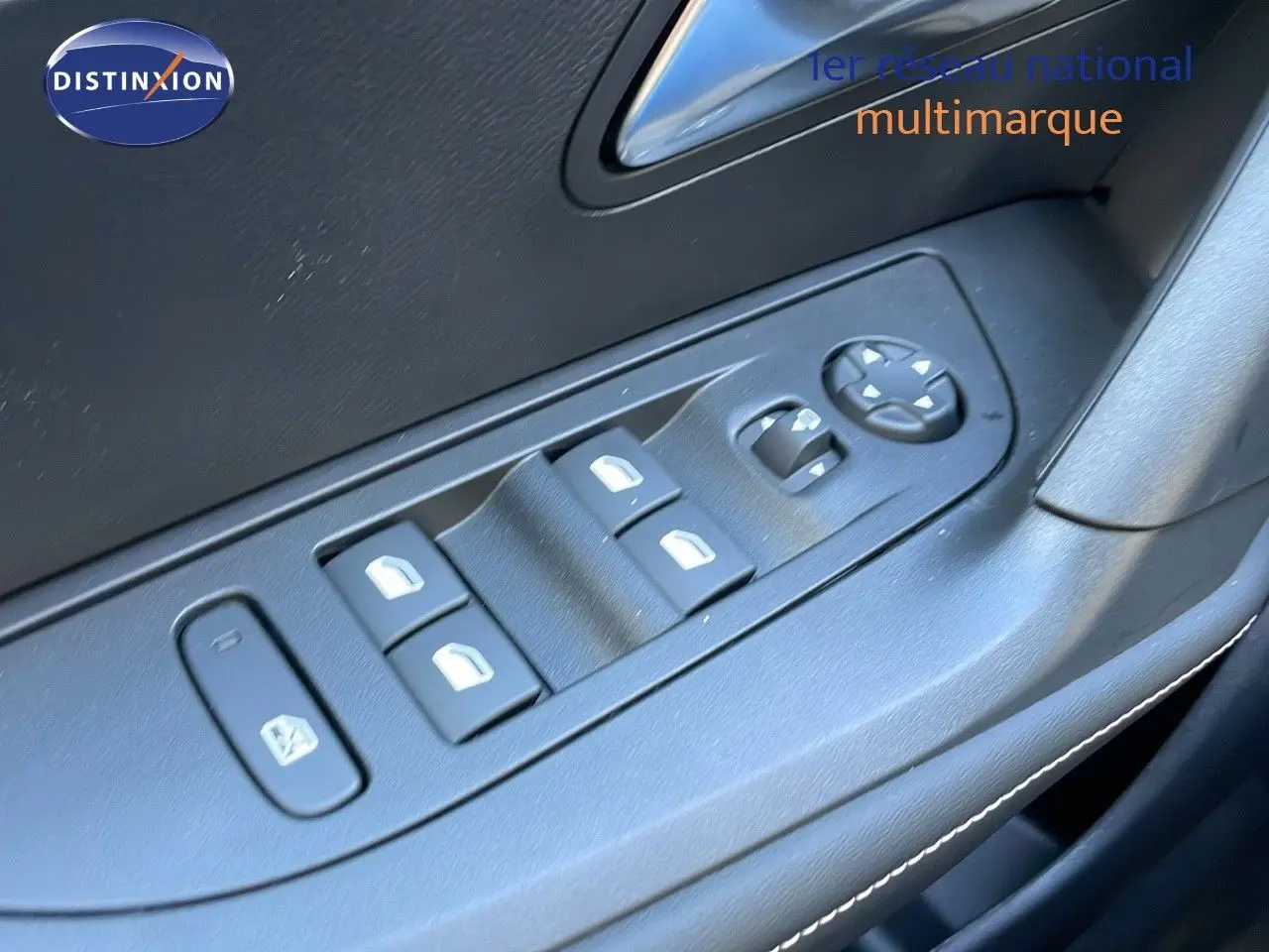 Gros plan sur les commandes des vitres électriques et rétroviseurs côté conducteur d'une Peugeot 2008 gris Artense 2025.