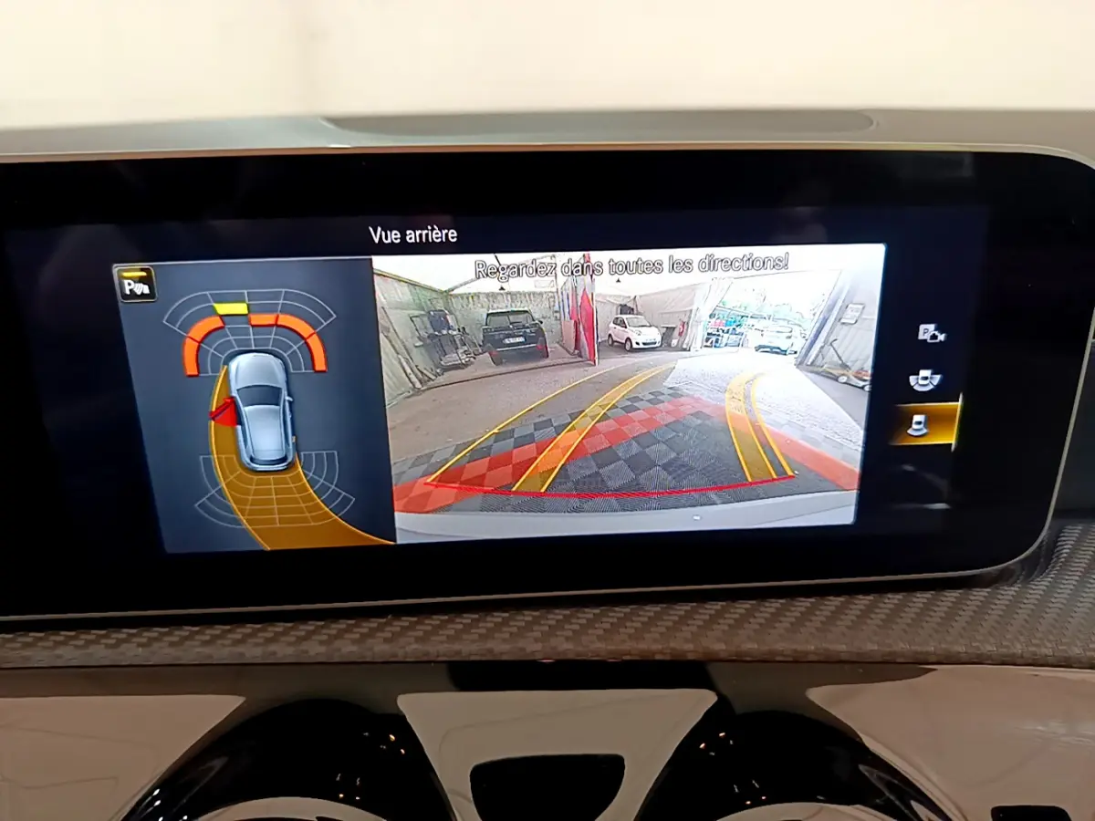 Écran tactile intérieur montrant la caméra de recul et l'aide au stationnement de la Mercedes Classe A gris clair.