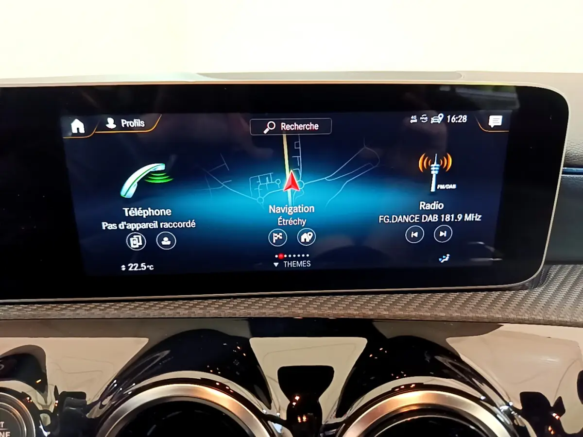 Écran tactile central affichant navigation, radio et téléphone dans le tableau de bord d'une Mercedes Classe A 180 d gris clair.
