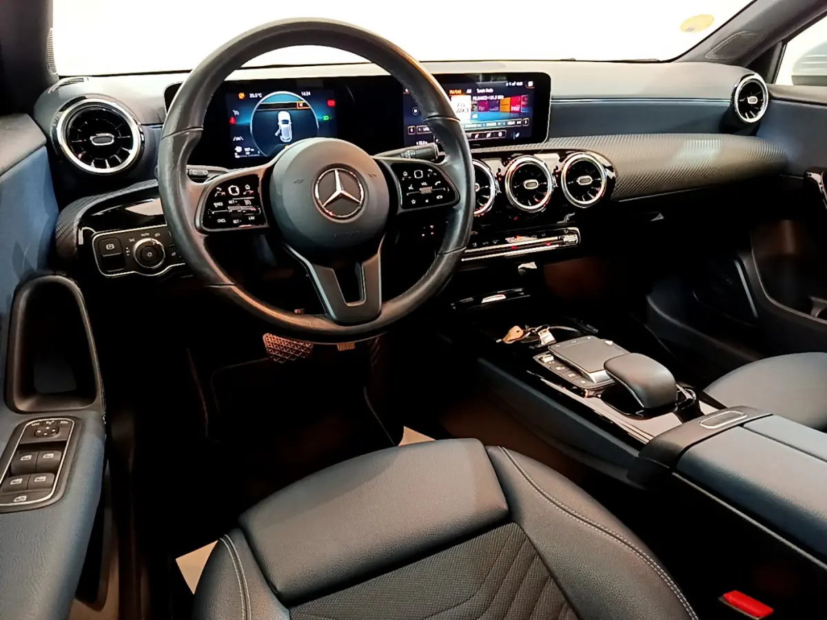 Intérieur moderne de la Mercedes Classe A 180 d Business Line 2020, vue cockpit côté conducteur avec écran tactile et volant cuir.