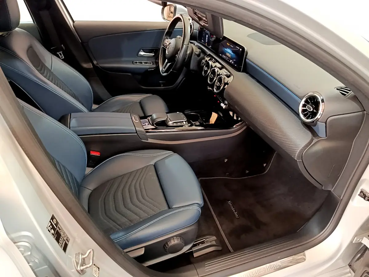 Vue intérieure côté conducteur de la Mercedes Classe A 180 d Business Line 2020 avec sièges bleu foncé et tableau de bord moderne.