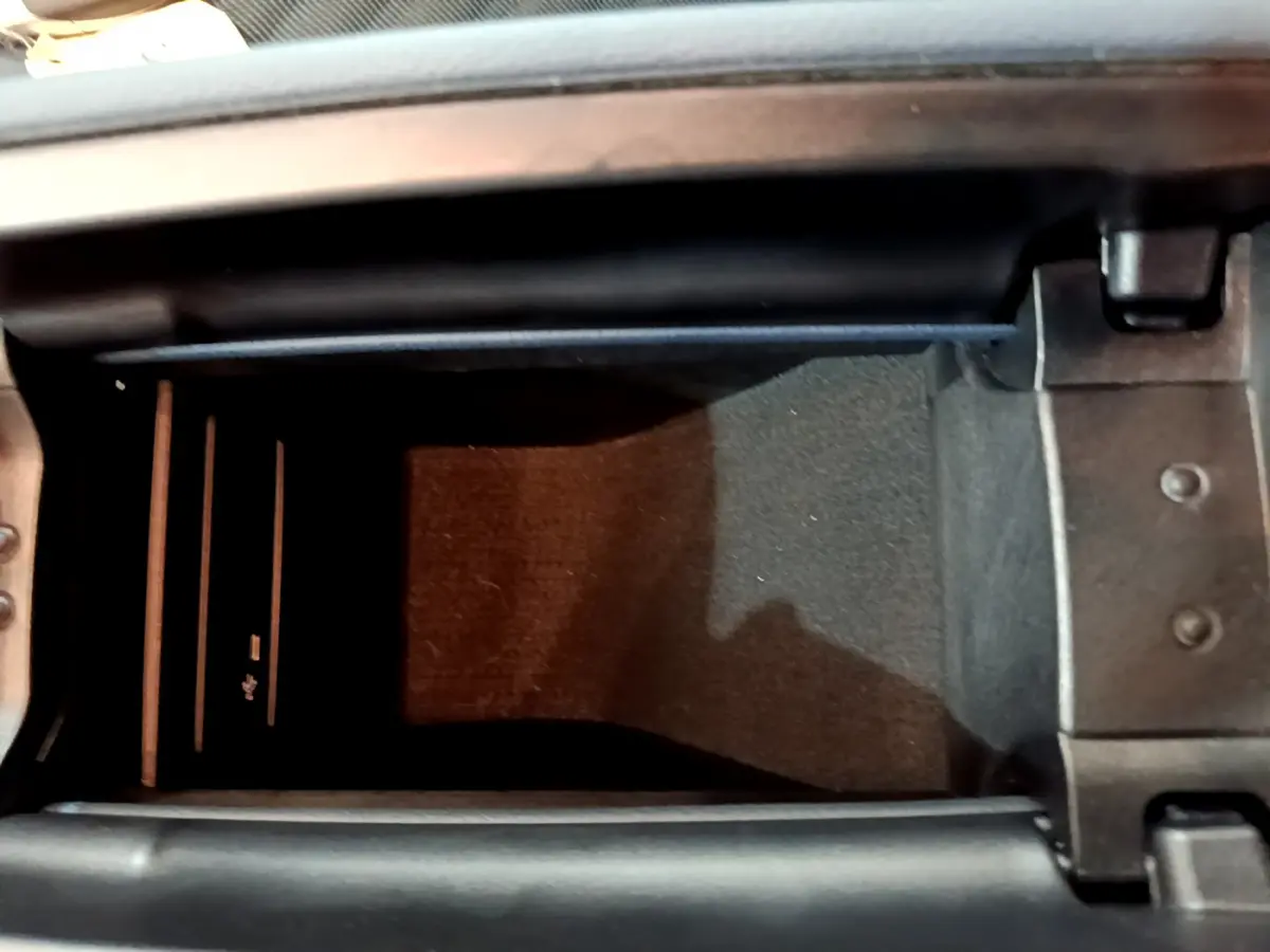 Vue rapprochée de la console centrale ouverte d'une Mercedes Classe A 180 d Business Line gris clair, montrant un espace de rangement intérieur.