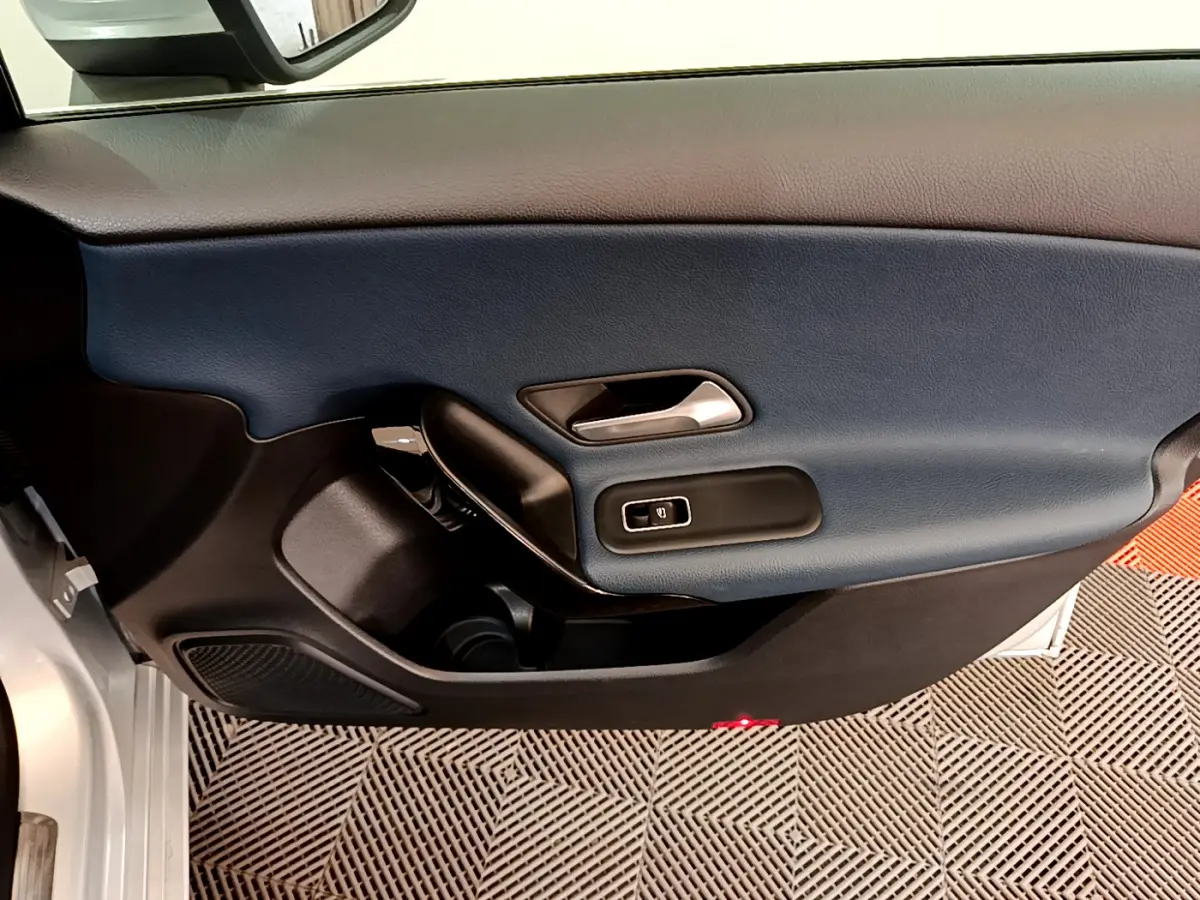 Vue rapprochée de la porte intérieure côté gauche d'une Mercedes Classe A 180 d Business Line 2020 avec garniture bleu foncé.