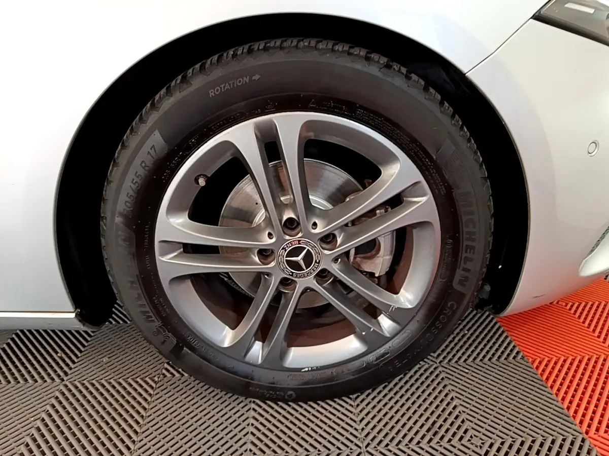 Gros plan sur la roue avant droite gris clair d'une Mercedes Classe A 180 d Business Line avec jante alliage et logo central étoile.