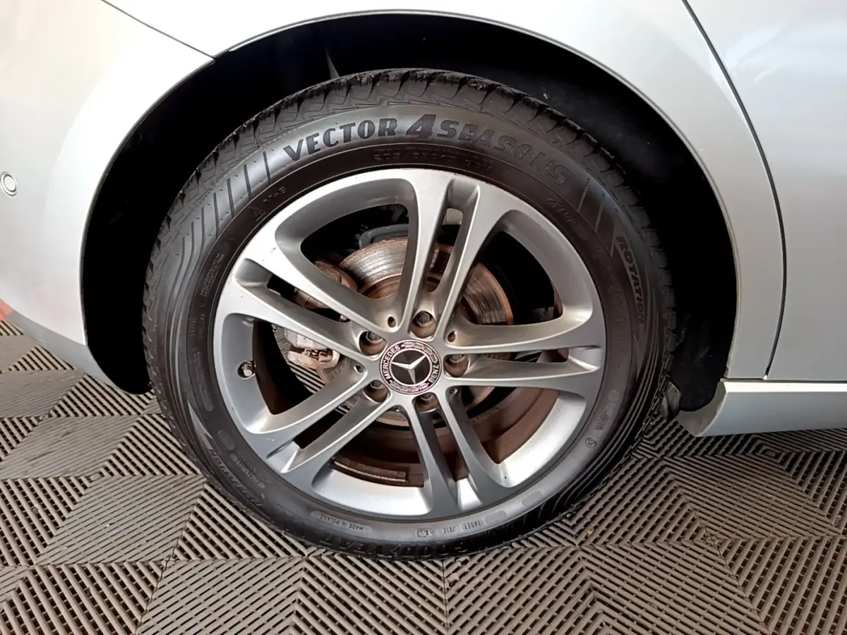 Gros plan sur la roue arrière droite gris clair d'une Mercedes Classe A 180 d Business Line 2020 avec jante alliage.