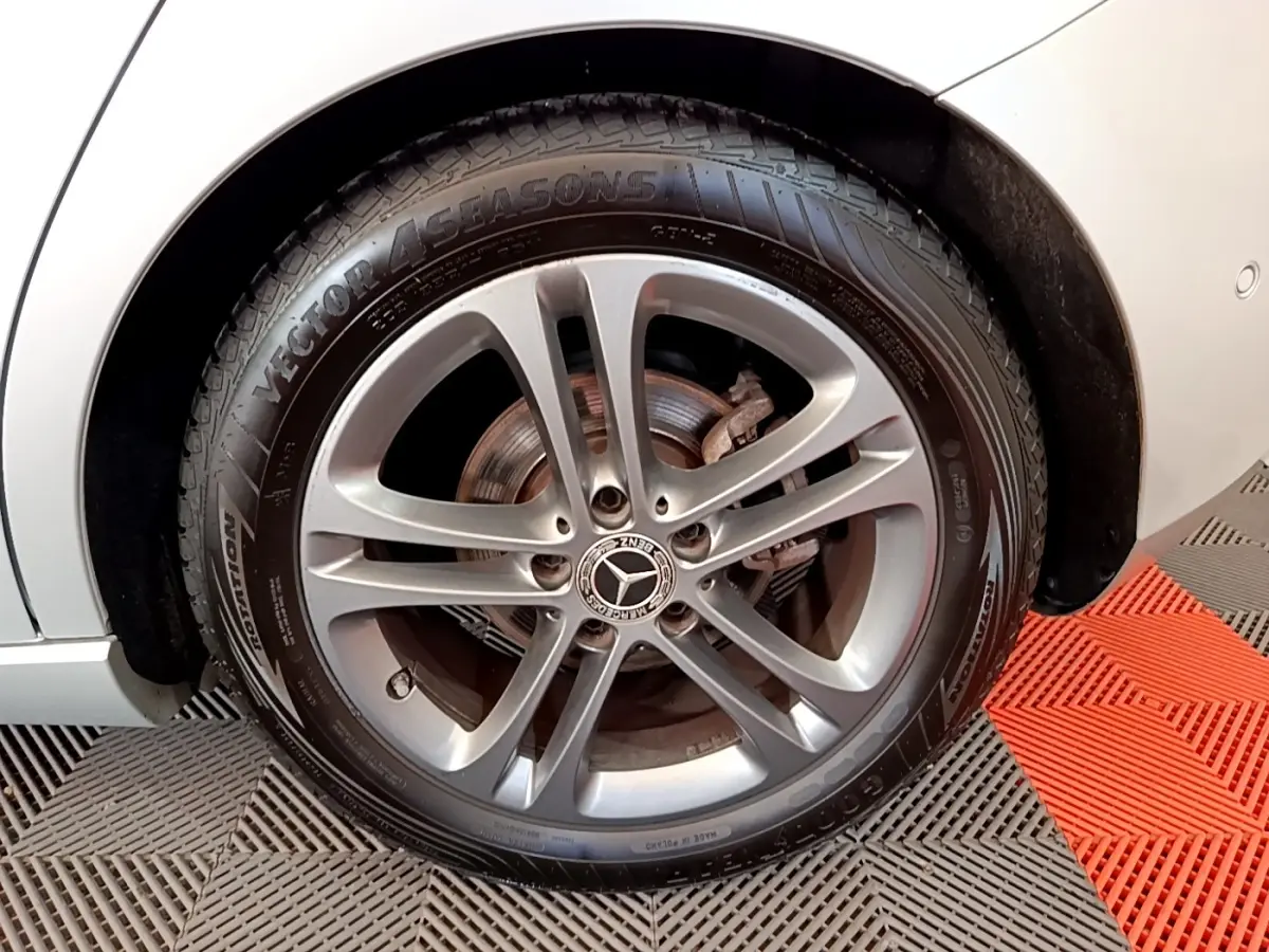 Gros plan sur la roue avant gauche gris clair d'une Mercedes Classe A 180 d Business Line 2020 avec jante alliage.