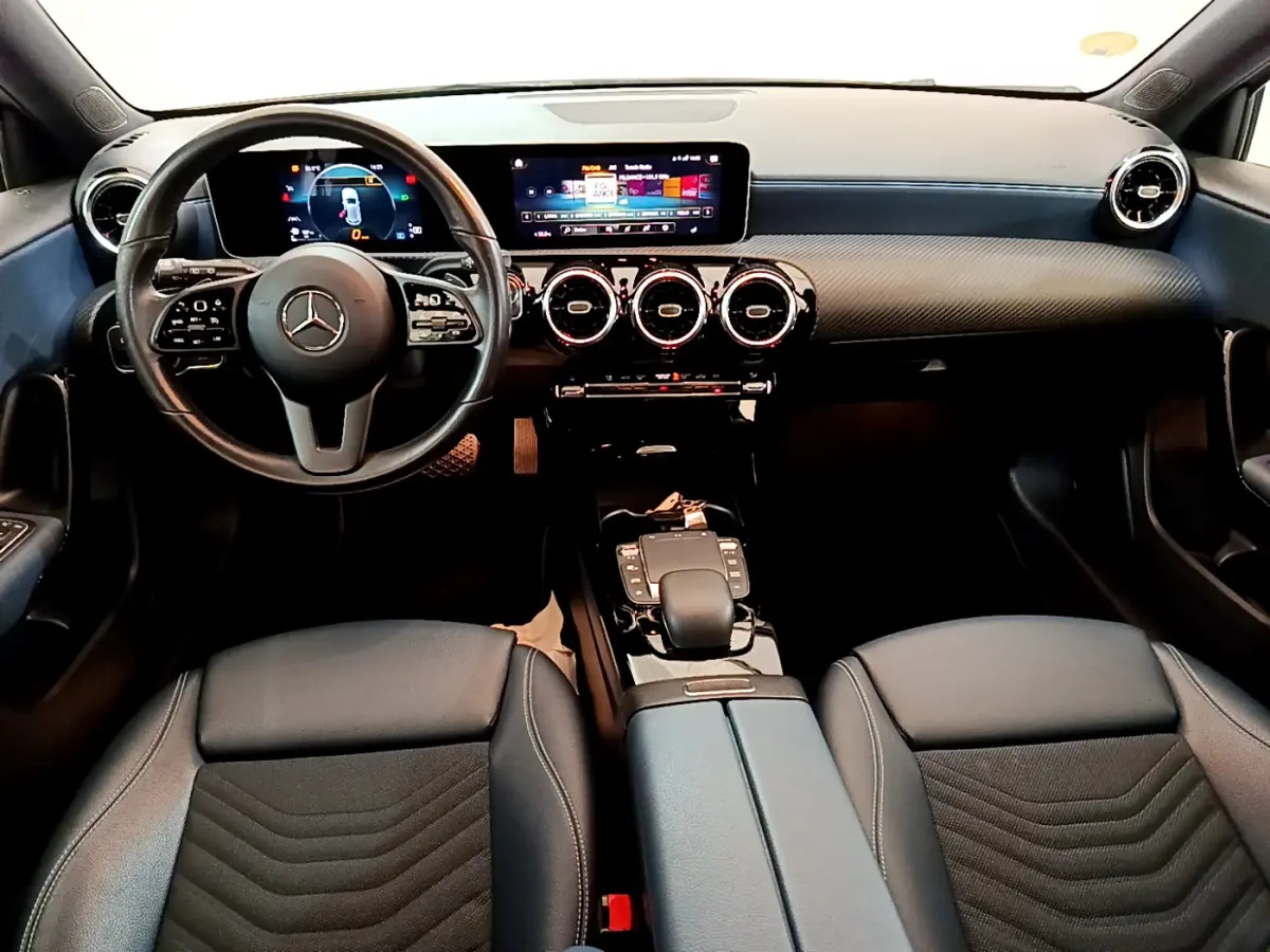 Intérieur noir de la Mercedes Classe A 180 d Business Line 2020, vue frontale sur le tableau de bord et le volant cuir multifonctions.