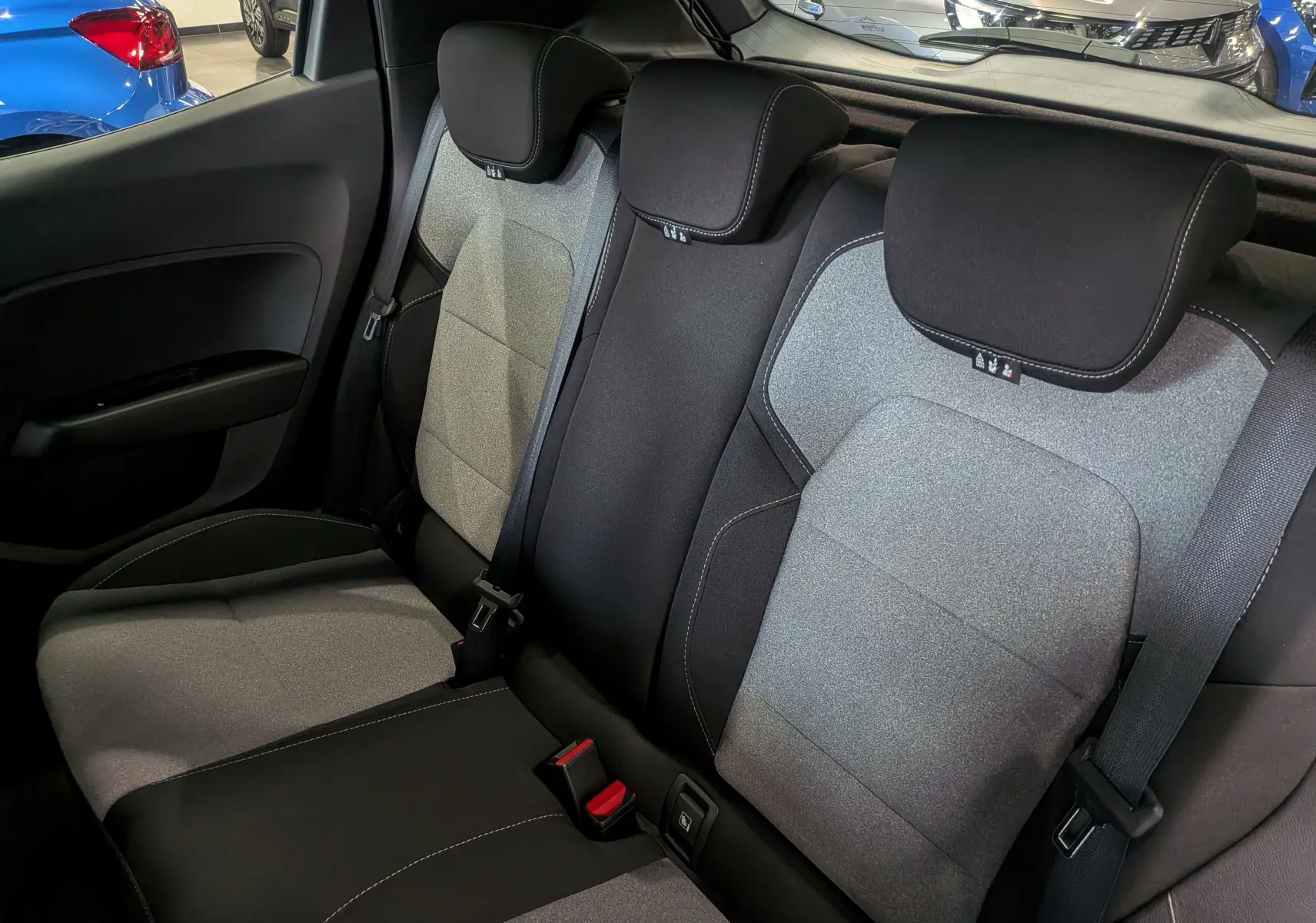 Vue intérieure sur les sièges arrière en tissu bicolore gris et noir de la Renault Clio V 2025, version Blue dCi Evolution.