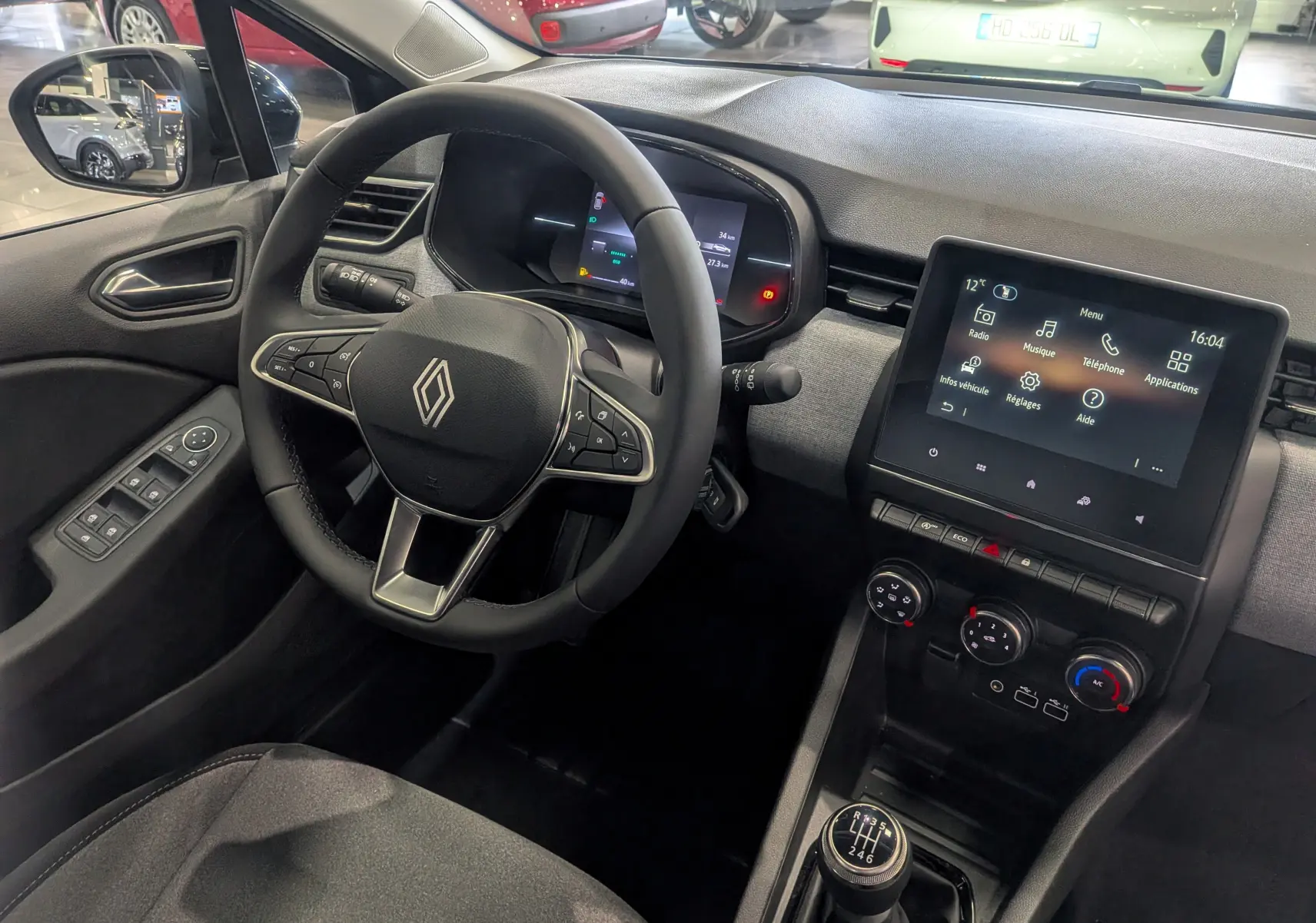 Vue intérieure côté conducteur de la Renault Clio V Blue dCi 100 CH Evolution 2025, volant multifonction et écran tactile central.