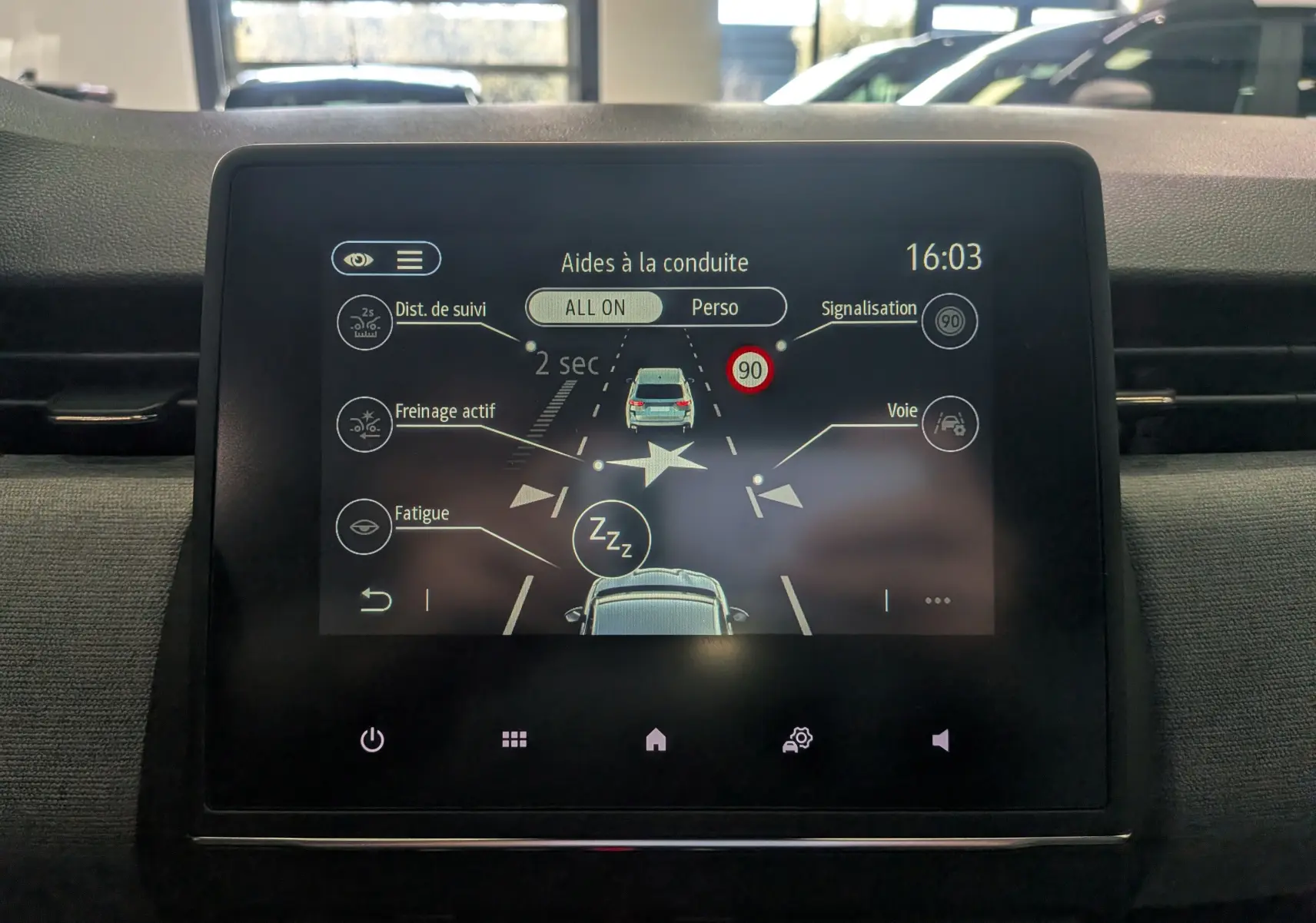 Écran tactile central de la Renault Clio V gris schiste montrant les aides à la conduite et alertes en interface digitale.