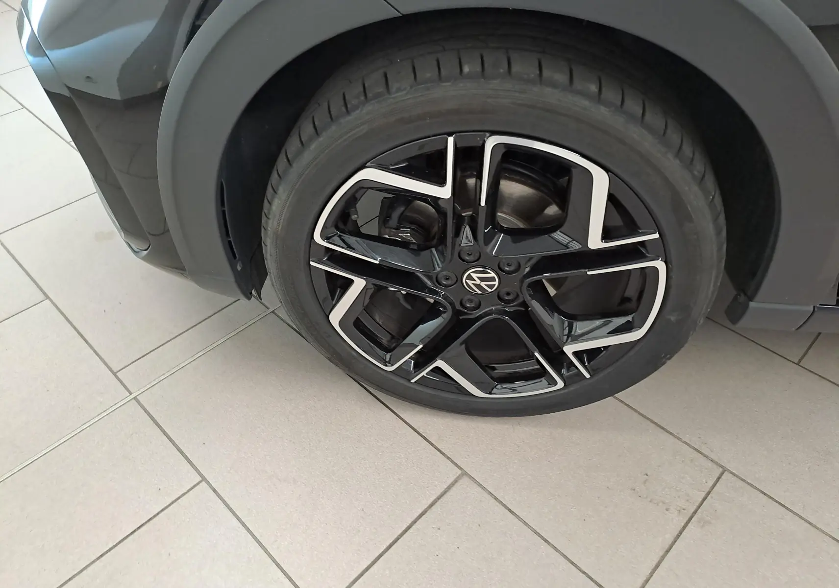 Gros plan sur la roue avant droite du Volkswagen Taigo noir intense nacré avec jante alliage R-Line 18 pouces.