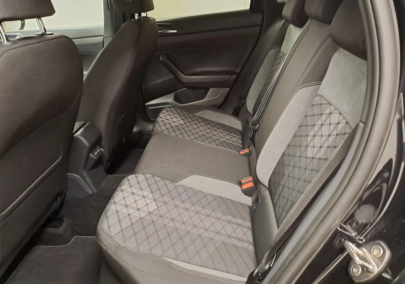 Vue latérale droite de la banquette arrière du Volkswagen Taigo 2025, sièges tissu gris à motifs géométriques.