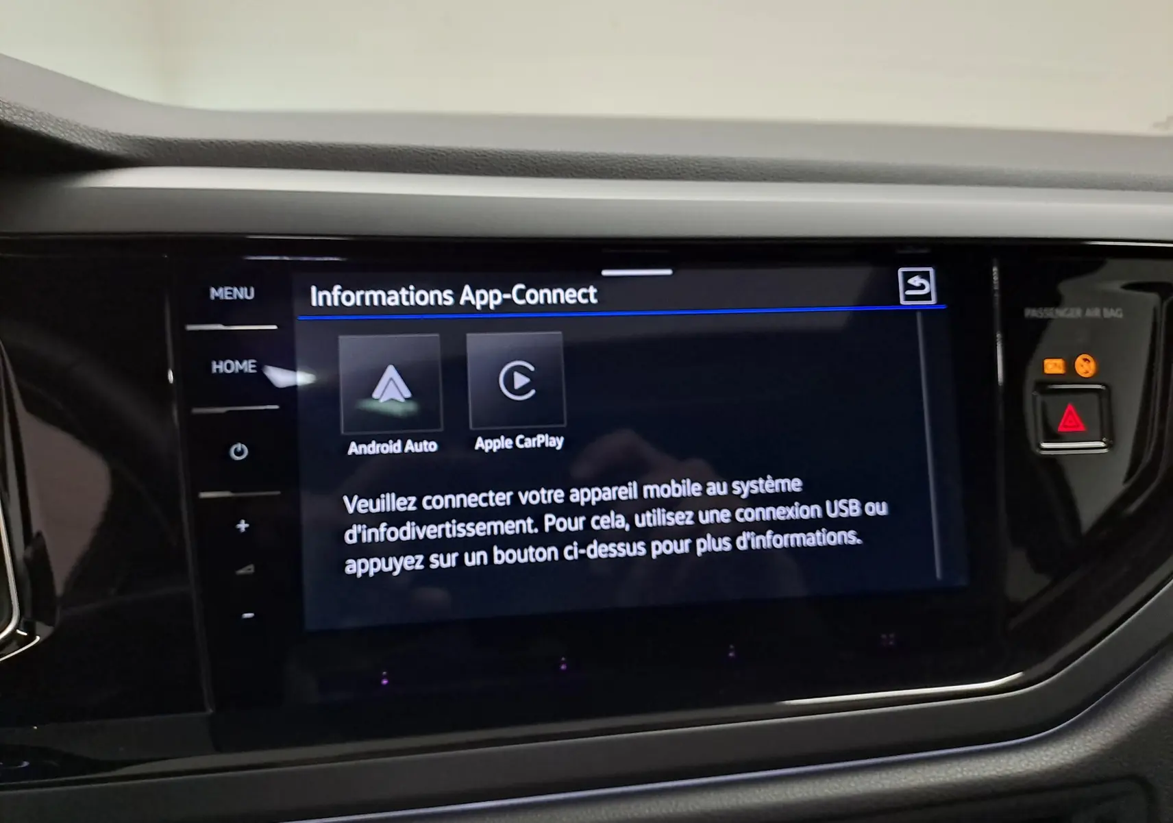 Vue rapprochée de l'écran tactile central noir affichant les options Android Auto et Apple CarPlay dans un Volkswagen Taigo noir intense nacré.