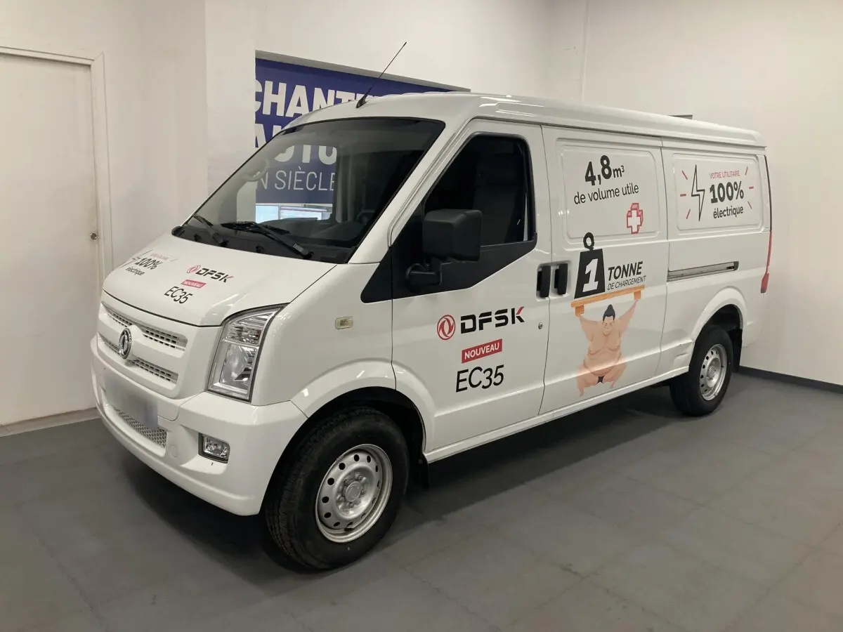 Vue 3/4 avant droit du fourgon blanc DFSK EC35 Ecocity 2022 avec marquages publicitaires électriques sur la carrosserie.