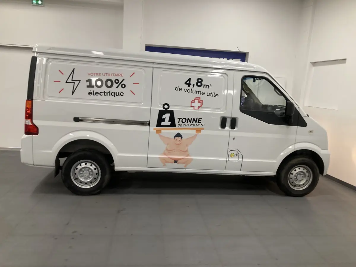 Vue de profil droit du fourgon utilitaire blanc DFSK EC35 Ecocity 2022 avec marquages publicitaires électriques et capacité de charge.