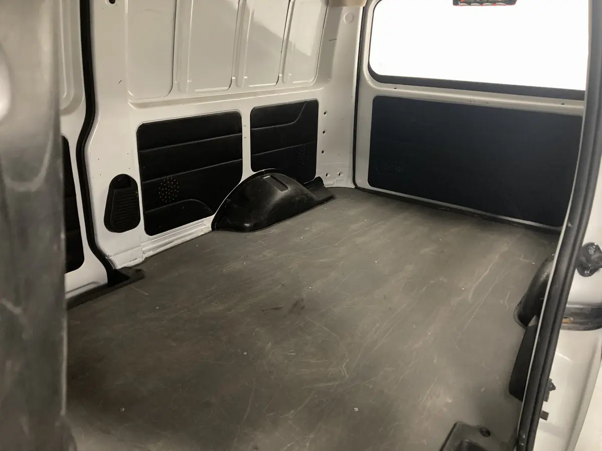 Vue intérieure du compartiment de chargement blanc du DFSK EC35 Ecocity, montrant l'espace vide et les parois latérales.