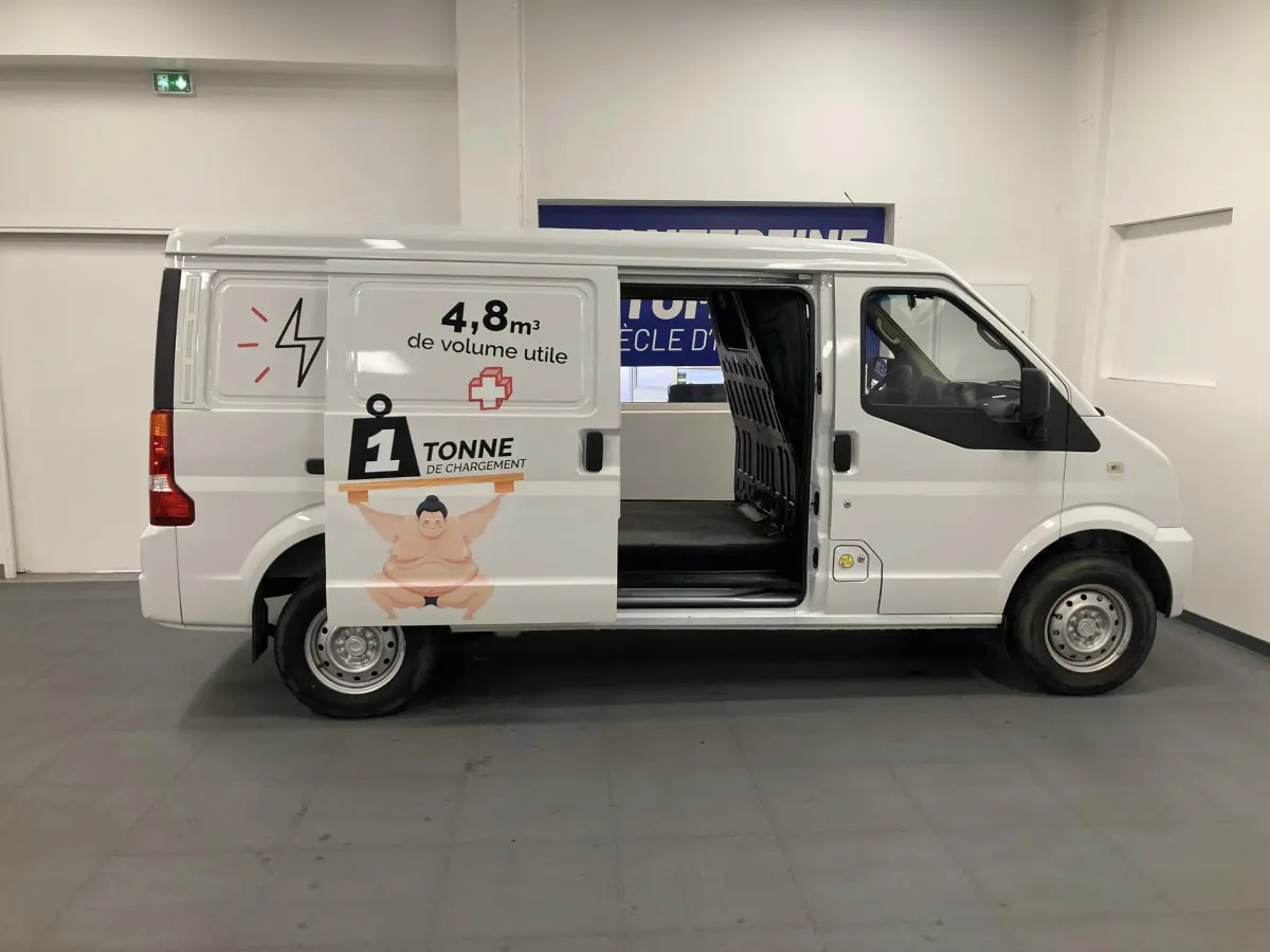 Vue de profil côté gauche d’un utilitaire blanc DFSK EC35 Ecocity 2022 avec porte coulissante ouverte et marquage de capacité de charge.