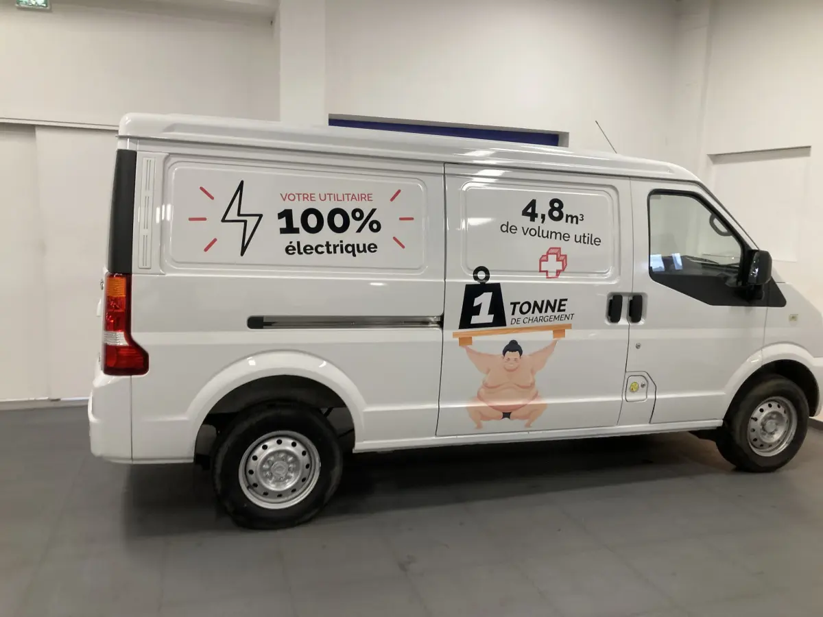 Vue latérale droite du utilitaire blanc DFSK EC35 Ecocity 2022 avec marquages publicitaires électriques et capacité de charge.