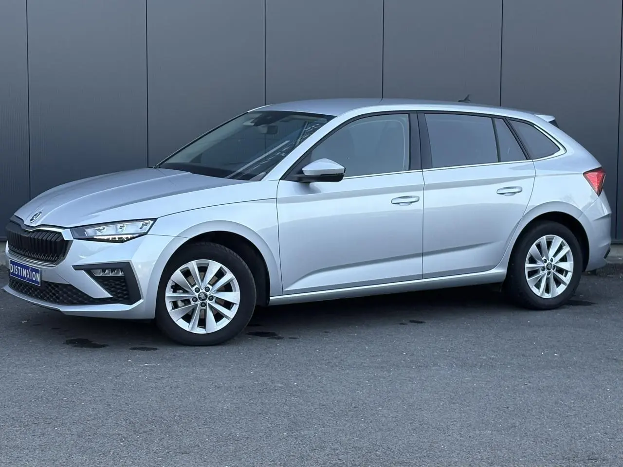 Vue de profil droit d'une Skoda Scala gris Reflex avec jantes alliage et vitres légèrement teintées.