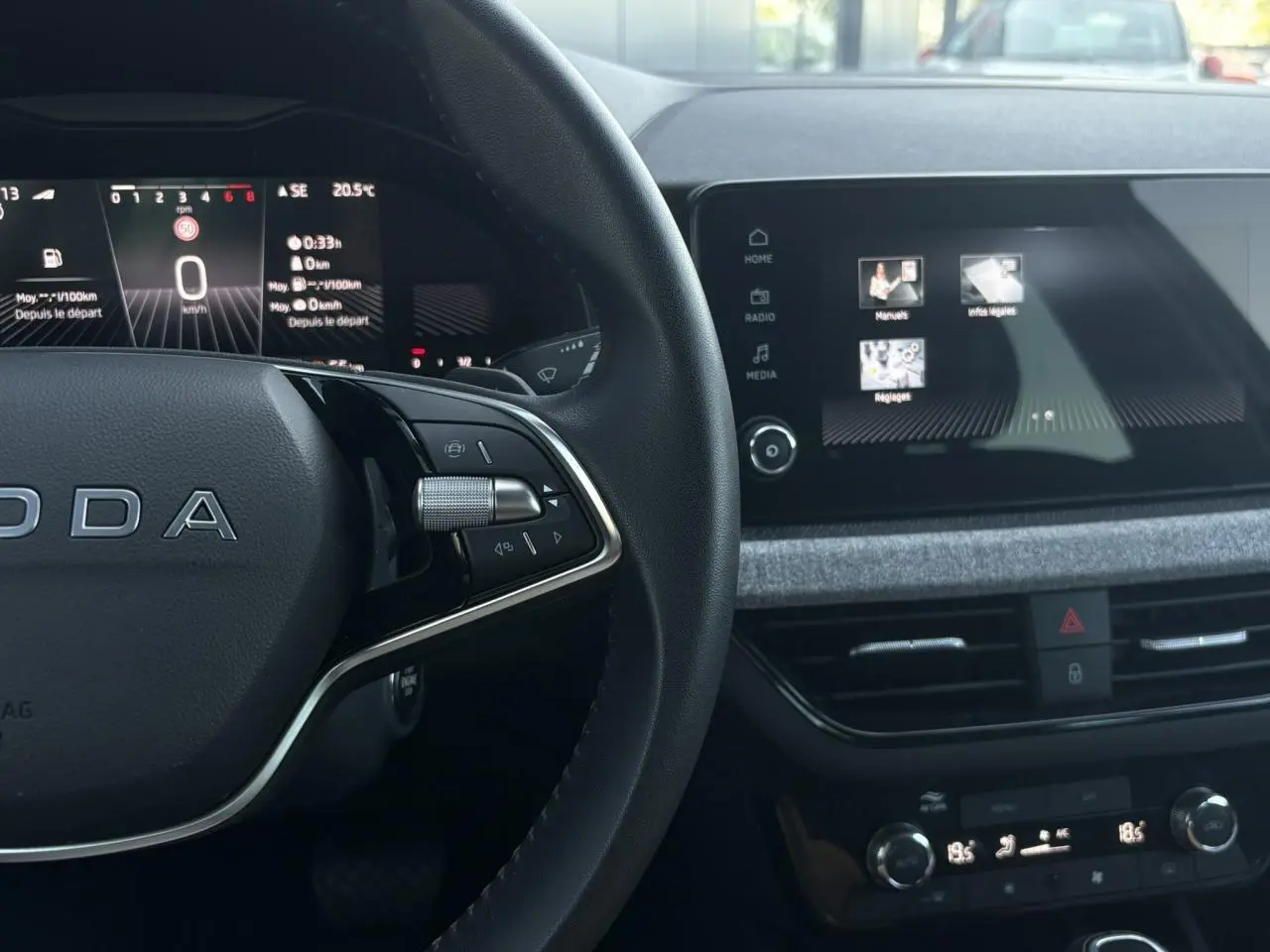 Intérieur SKODA SCALA TSI 116 DSG7, vue du volant cuir à deux branches et écran tactile central allumé.