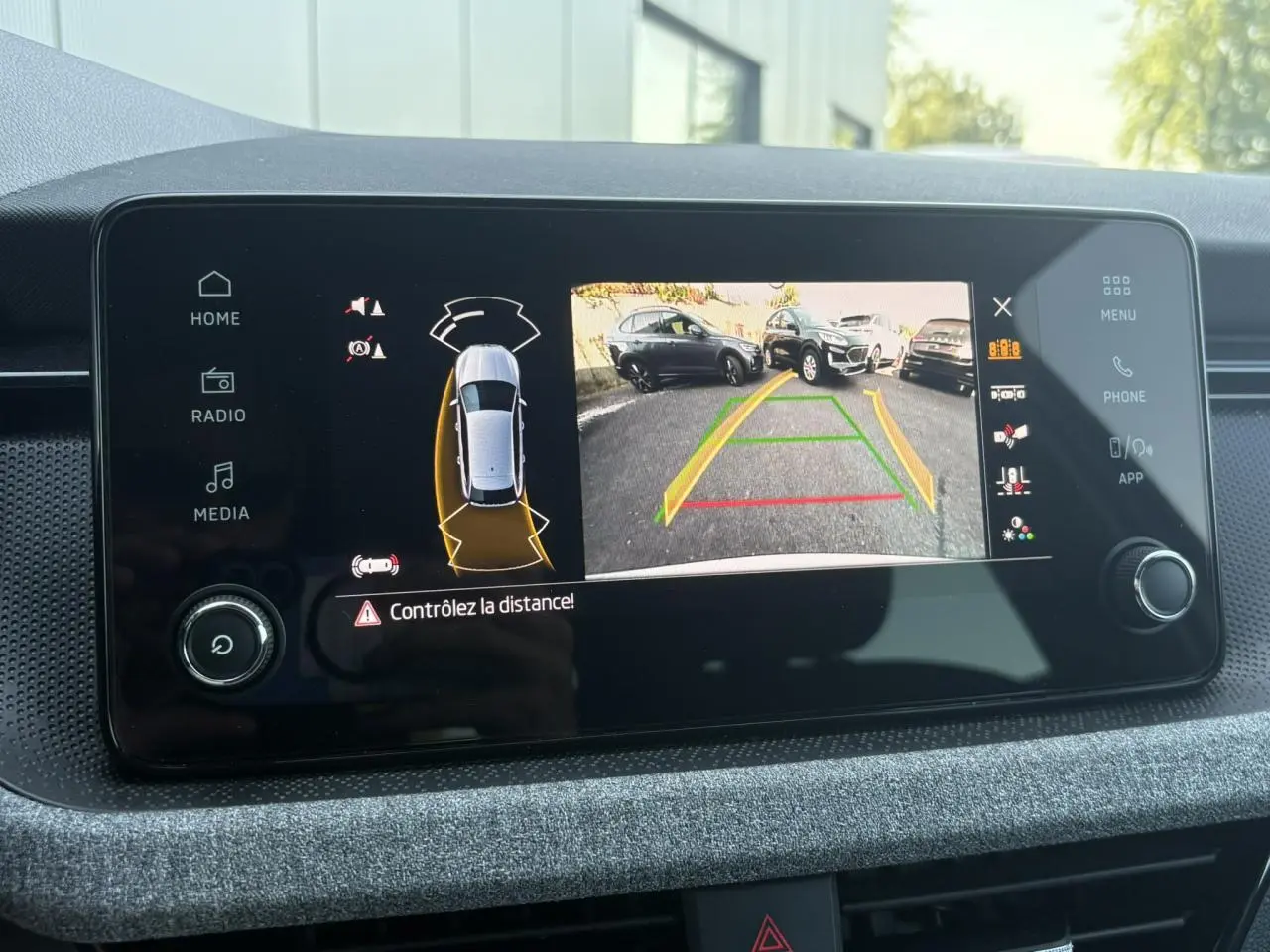 Écran central de la Skoda Scala TSI 116 DSG7 Sélection montrant la caméra de recul avec guidage dynamique.