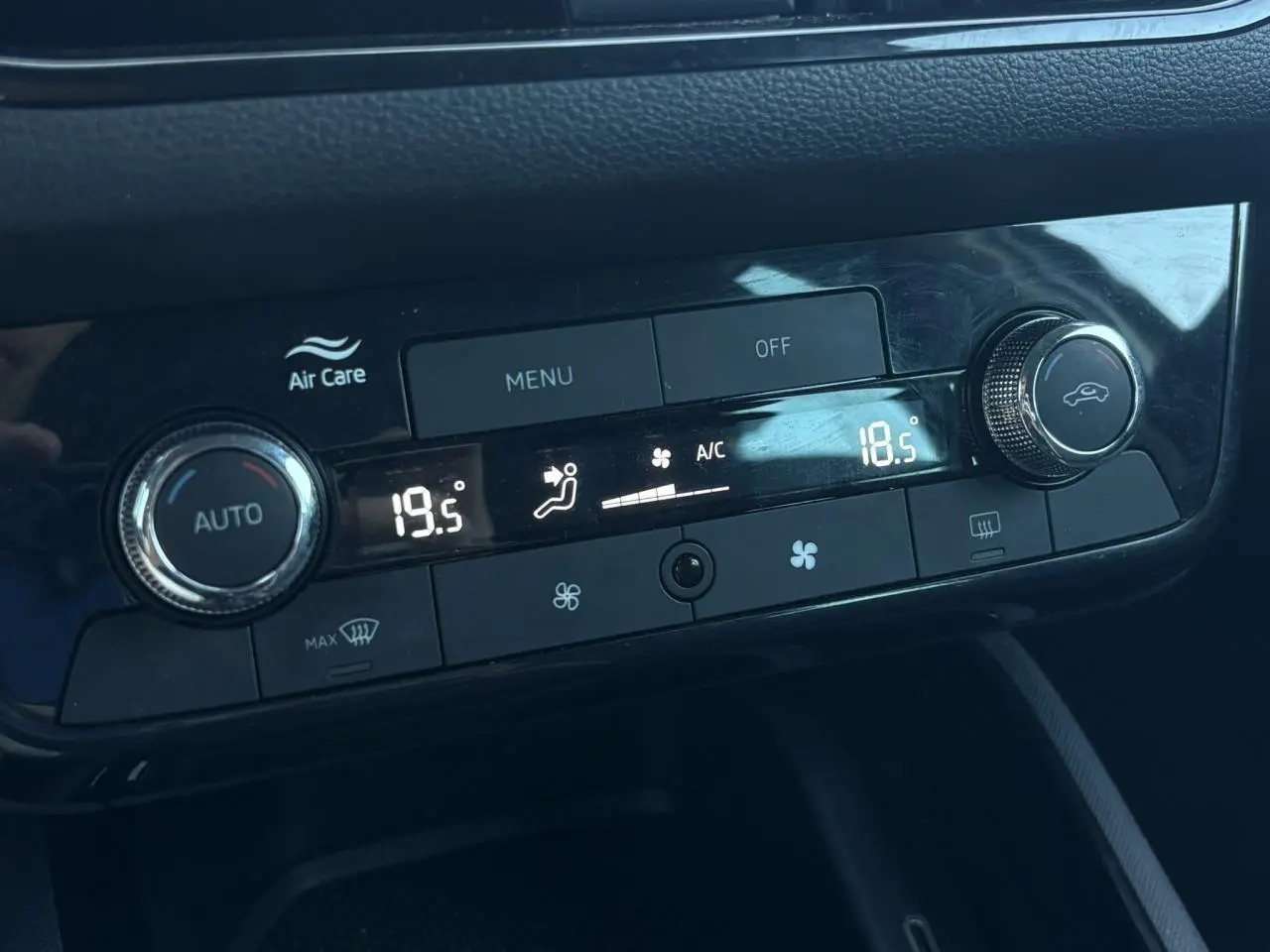 Gros plan sur la commande de climatisation automatique bi-zone du Skoda Scala gris, affichant 19,5°C à gauche et 18,5°C à droite.