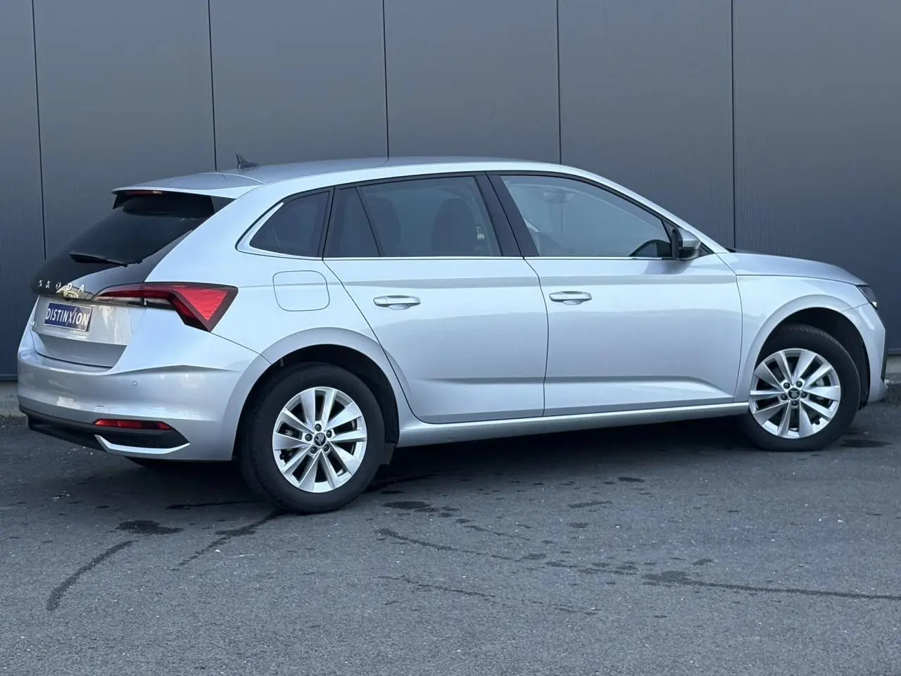 Vue de profil droit d'une Skoda Scala gris reflex avec vitres arrière surteintées et jantes alliage 16 pouces.