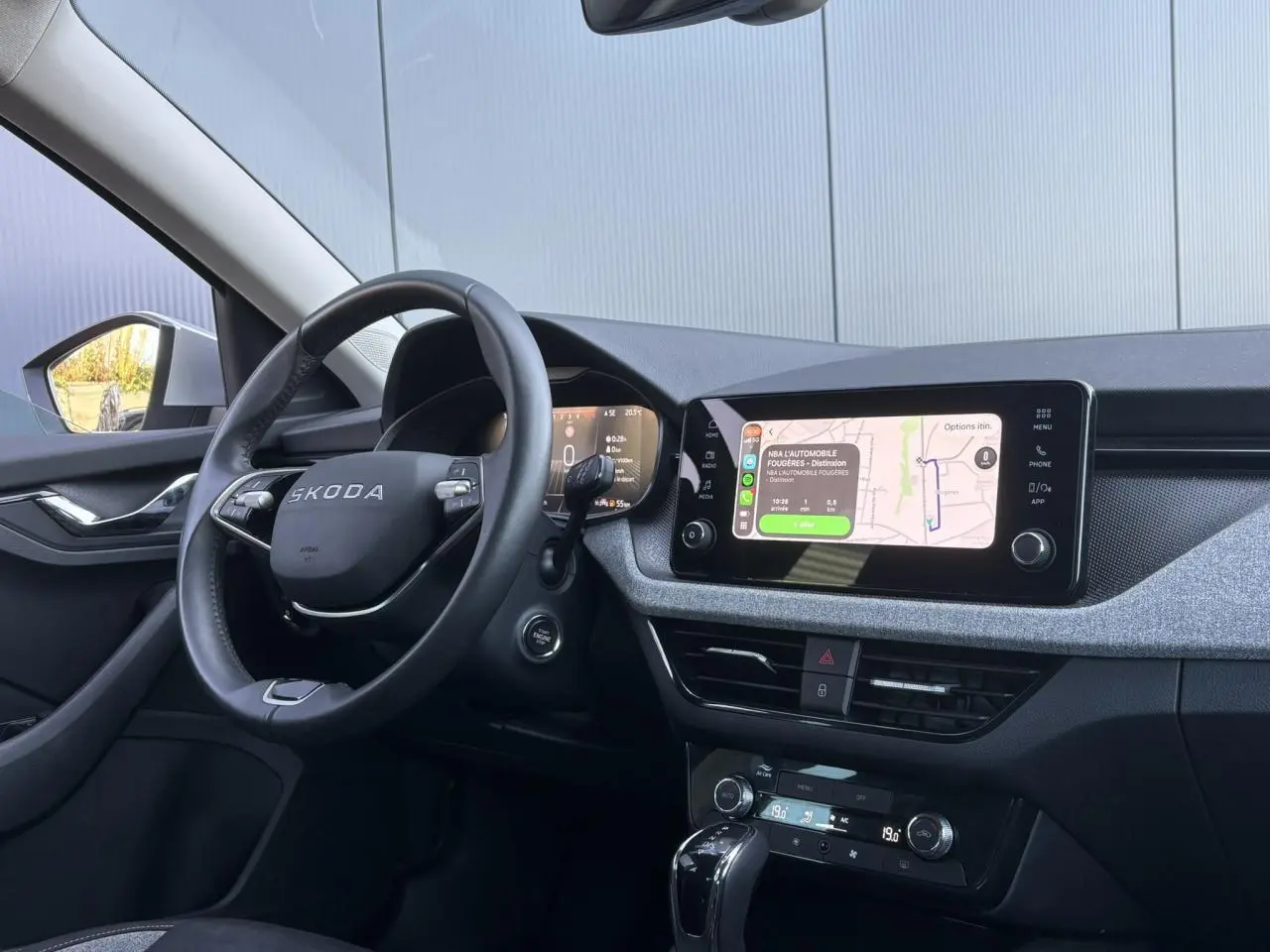 Vue intérieure côté conducteur de la Skoda Scala gris Reflex, avec écran tactile et volant multifonctions en cuir.